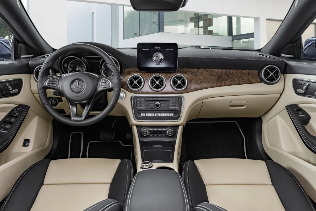 Innenraum eines Autos mit beigem und schwarzem Leder, moderner Instrumententafel, Touchscreen und Mercedes-Benz-Logo auf dem Lenkrad.