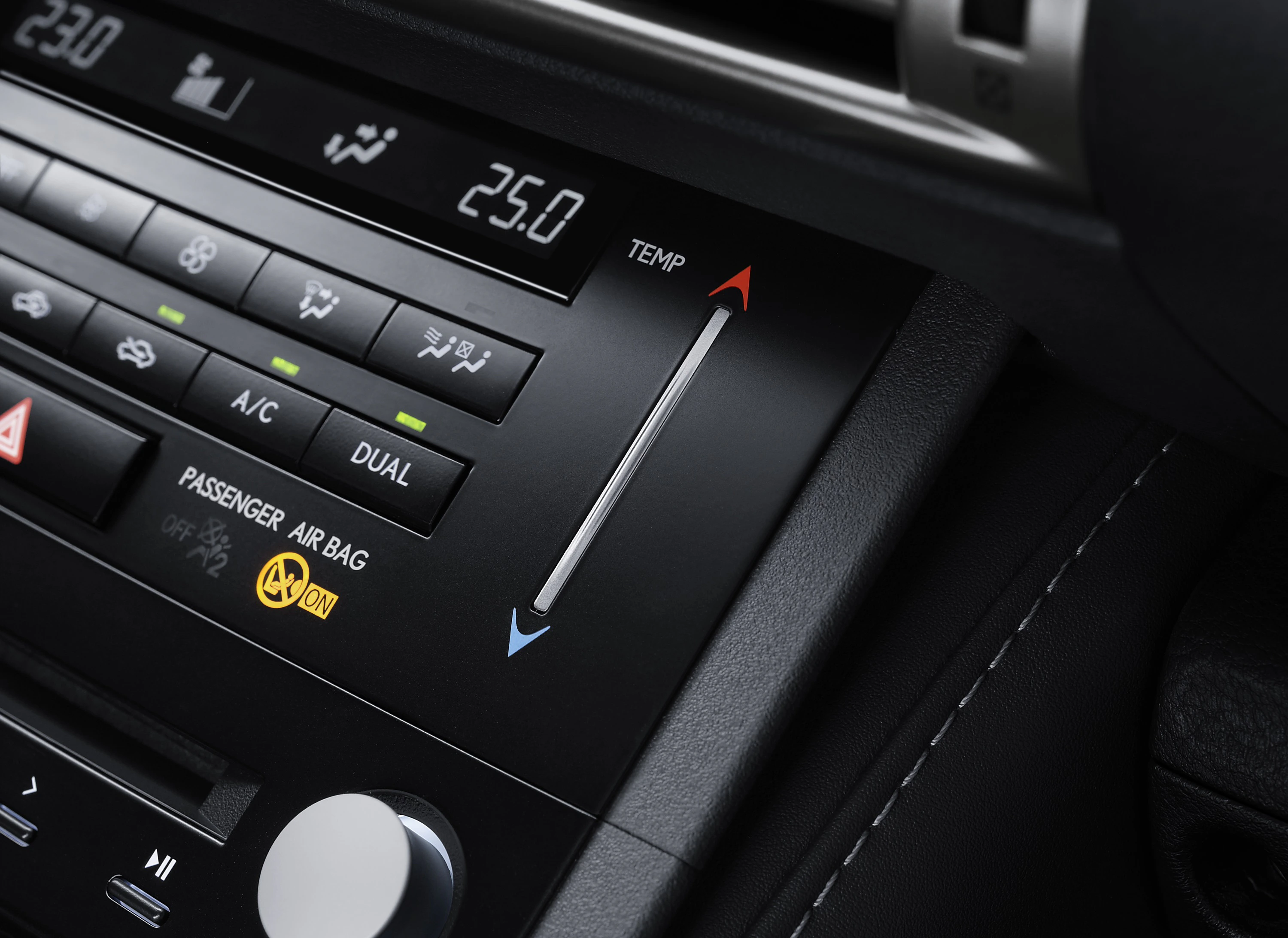 Nahaufnahme eines Auto-Klimaanlagenbedienfelds mit Temperaturregler, digitalen Anzeigen und Symboltasten.