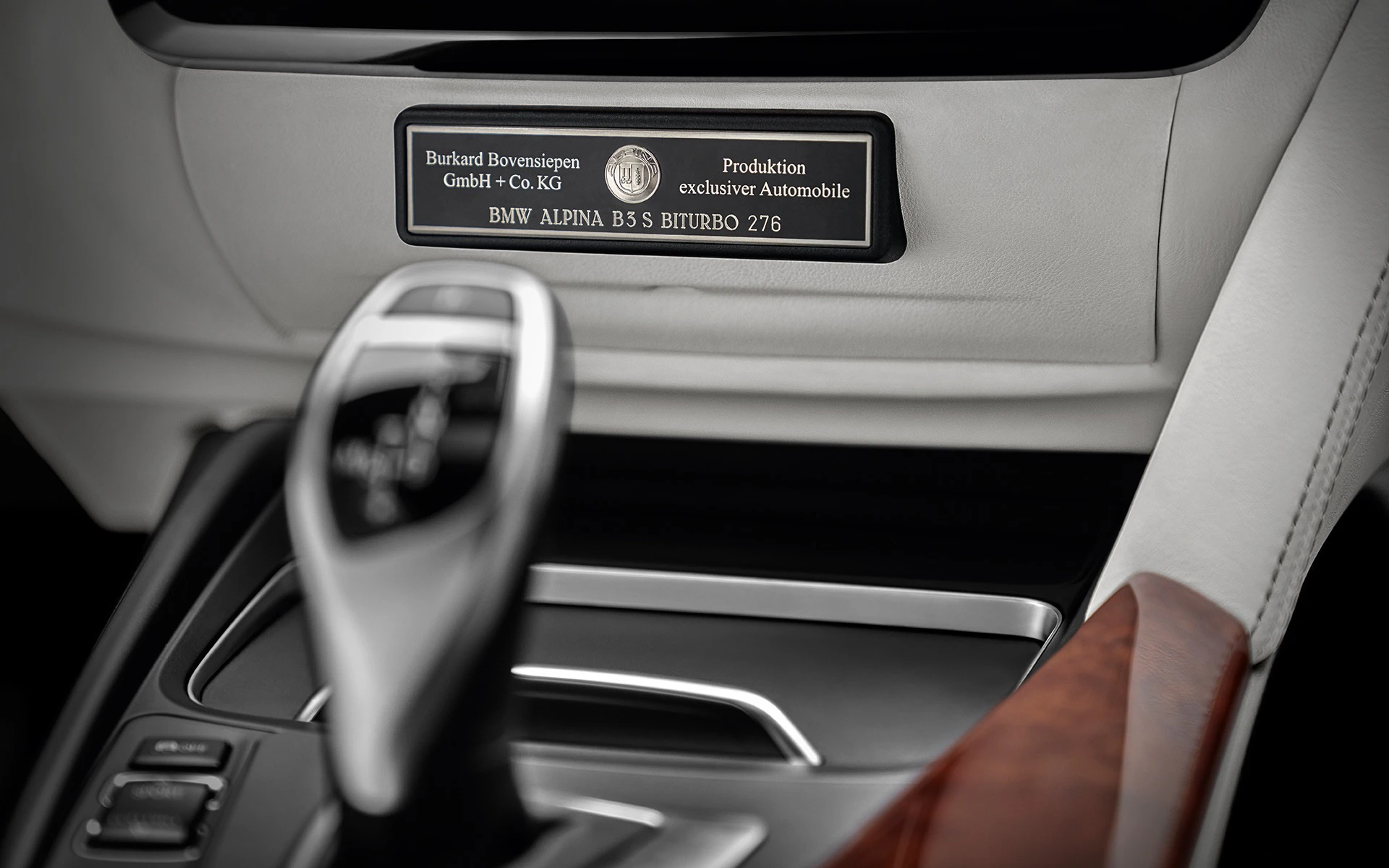 Nahaufnahme einer Herstellungsplakette im Auto mit dem Text zu exklusiven Automobilen und Gangschaltung im Vordergrund.