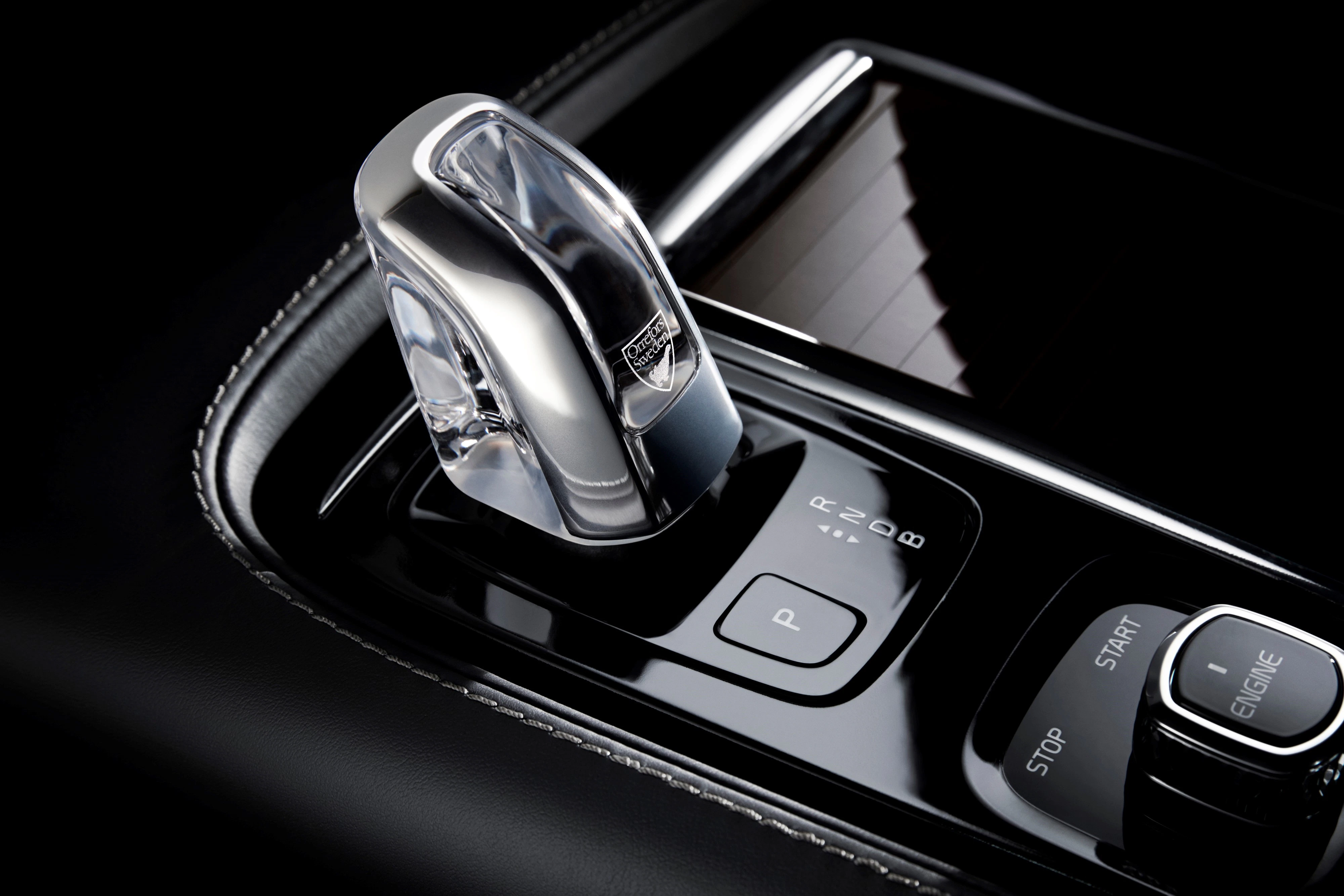 Nahaufnahme eines modernen Automatikgetriebeschalters mit glänzender Kristalloptik in einem luxuriösen Auto-Innenraum.