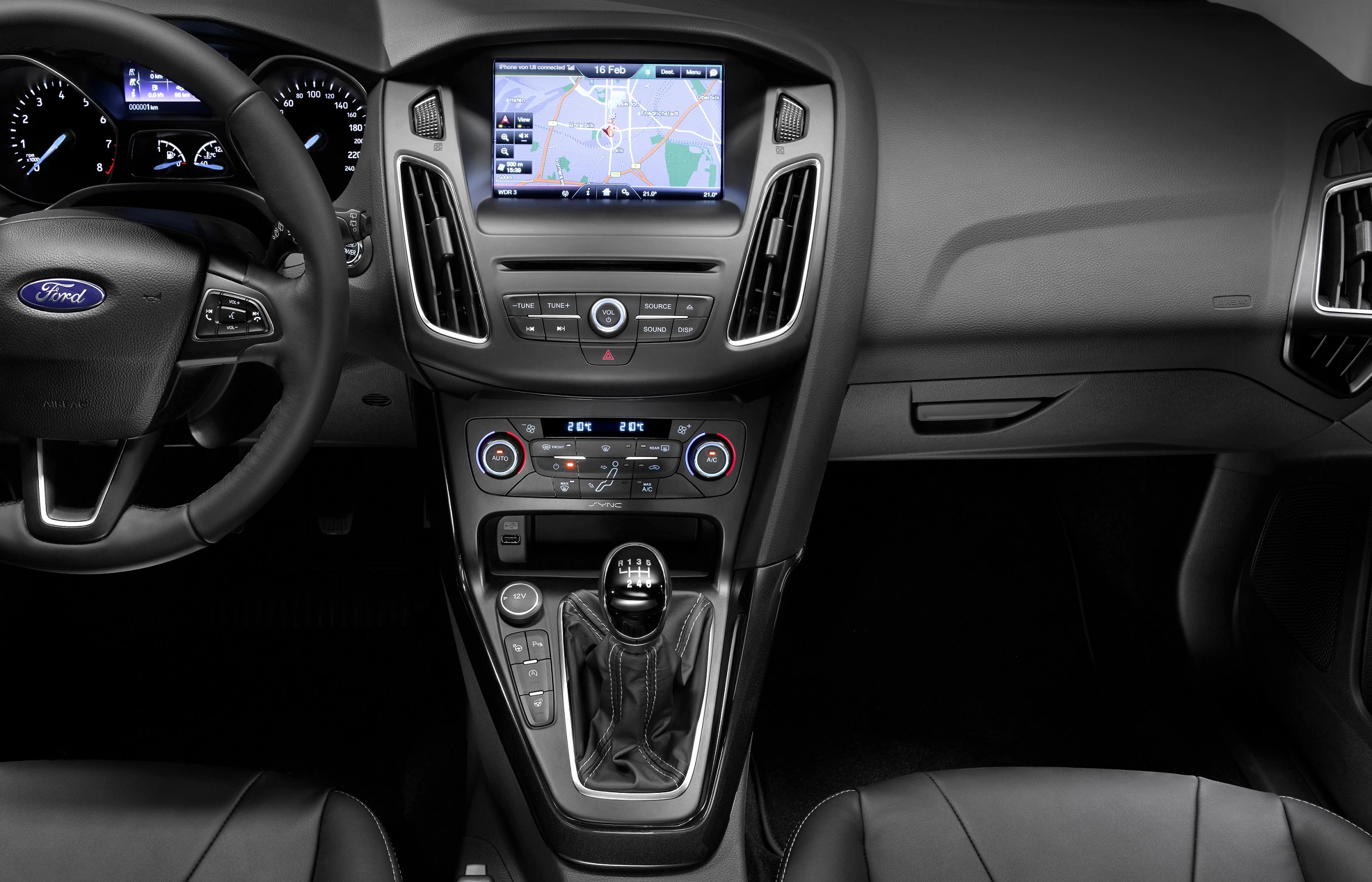 Innenraum eines Autos mit Navigationssystem auf dem Display, schwarzen Sitzen und manuellem Schalthebel.