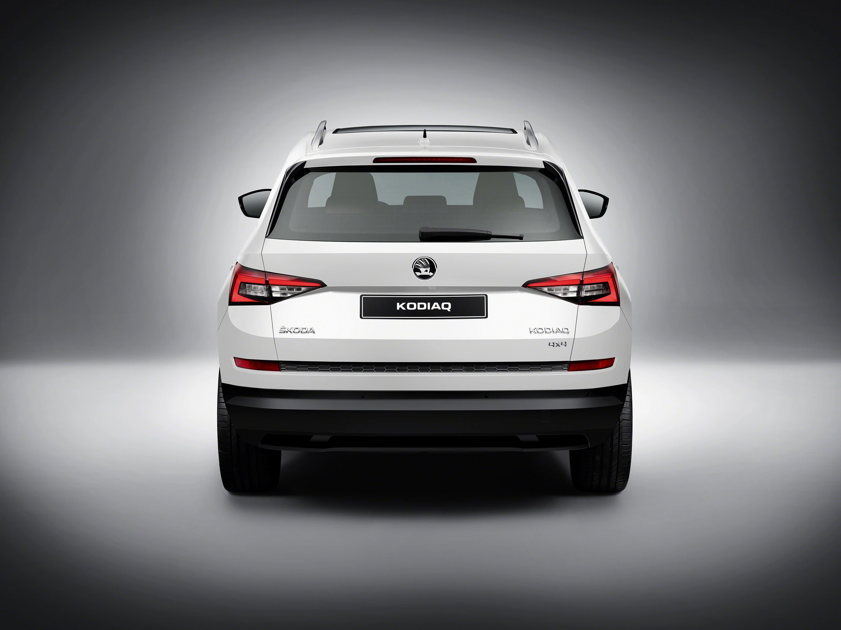 Rückansicht eines weißen Škoda Kodiaq, einem SUV, auf grauem Hintergrund. Fahrzeugemblem und Modellname sind sichtbar.