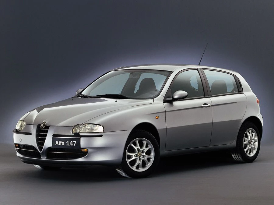 Silberner Alfa Romeo 147, Vorderansicht, auf grauem Hintergrund. Fünf-Türer mit markanter Front und sportlichem Design.