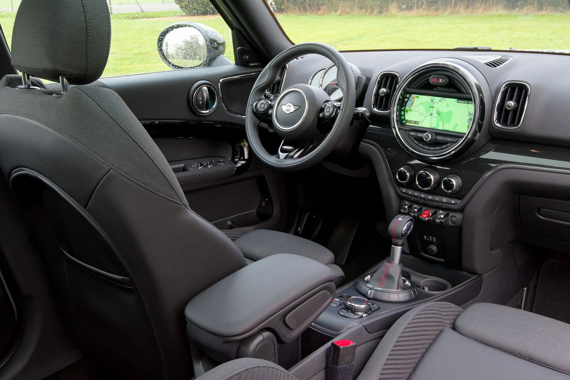 Innenraum eines Autos mit modernem Armaturenbrett, Multifunktionslenkrad und einem Navigationsbildschirm, schwarzes Interieur.