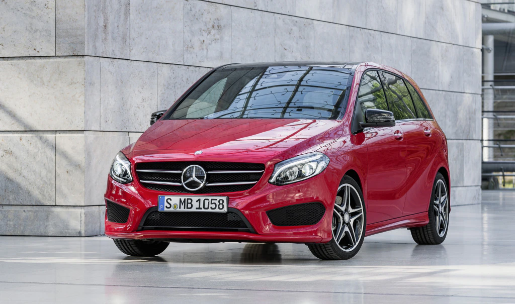 Roter Mercedes-Benz B-Klasse-Pkw steht geparkt in modernem, lichtdurchflutetem Gebäude mit Betonwänden.
