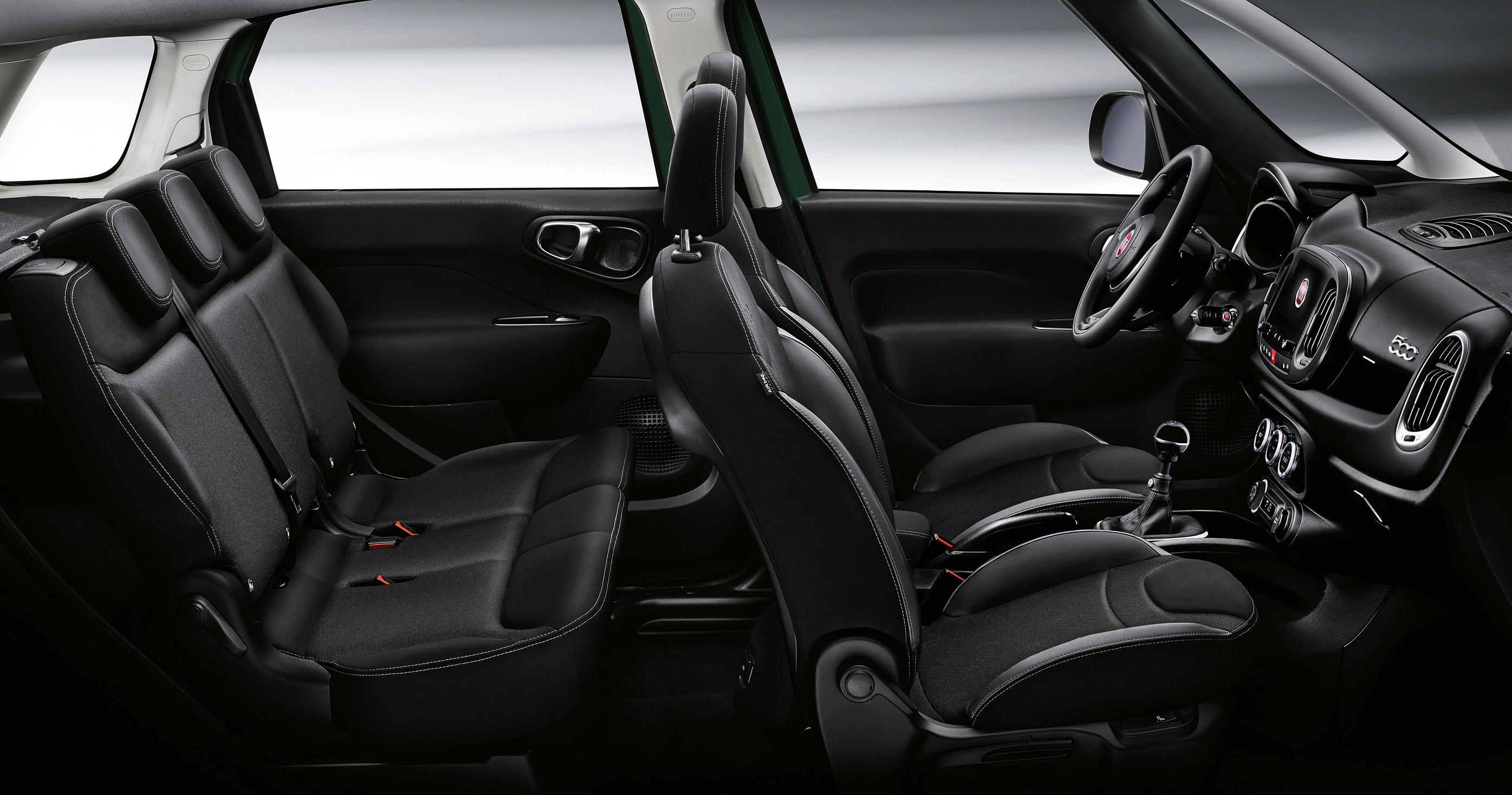 Innenraum eines Autos mit schwarzen Sitzen, eleganten Armaturen und viel Beinfreiheit. Rücksitzbank bietet Platz für drei Personen.