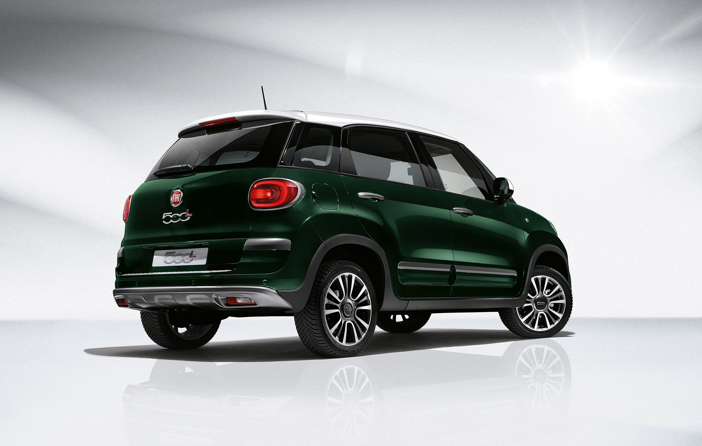Grüner Fiat 500L von schräg hinten, steht in einem hellen Raum, Rücklichter und Markenlogo sichtbar.