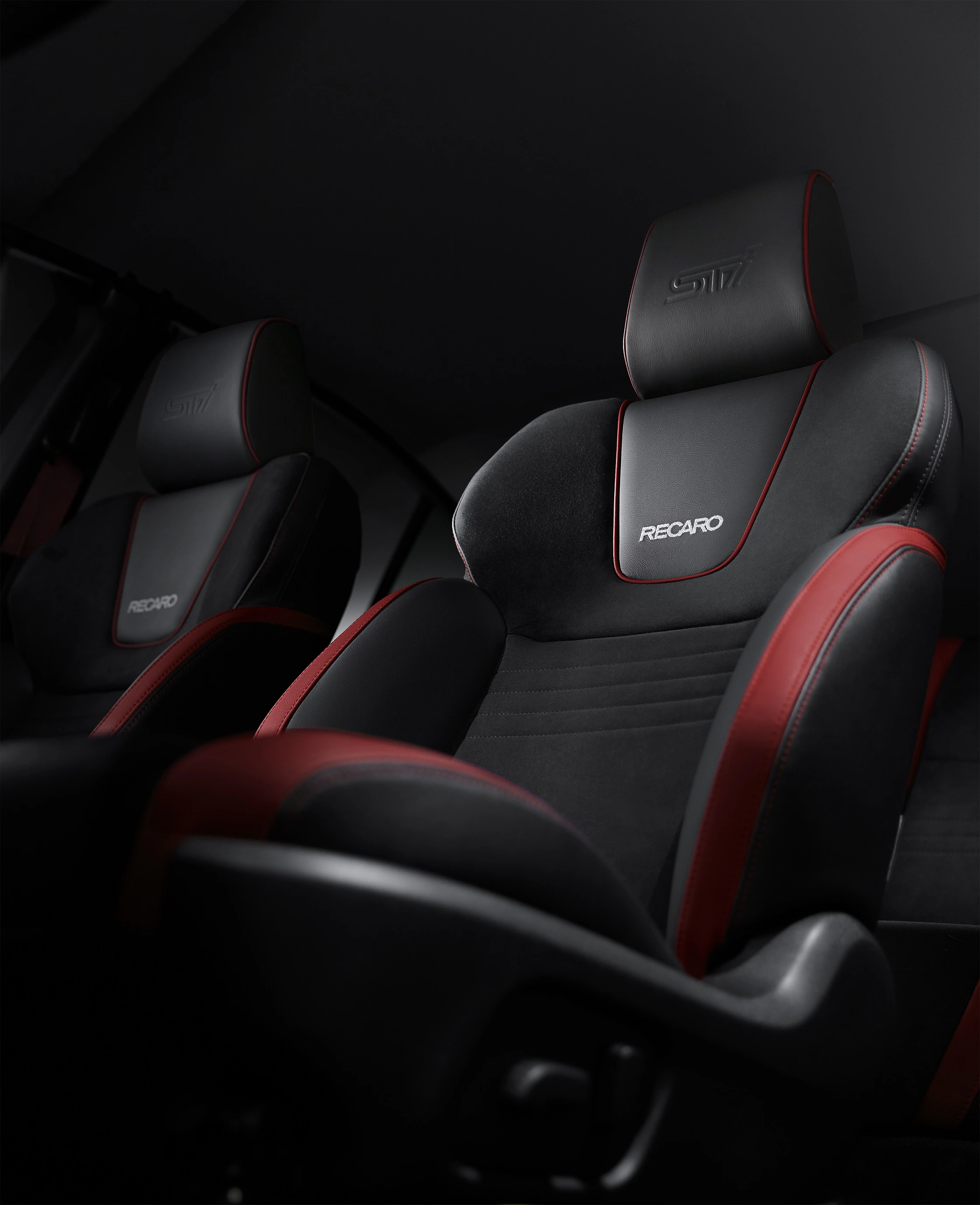 Schwarze Recaro-Sportsitze mit roten Akzenten in einem Auto. Das GTI-Logo ist auf der Kopfstütze eingestickt.