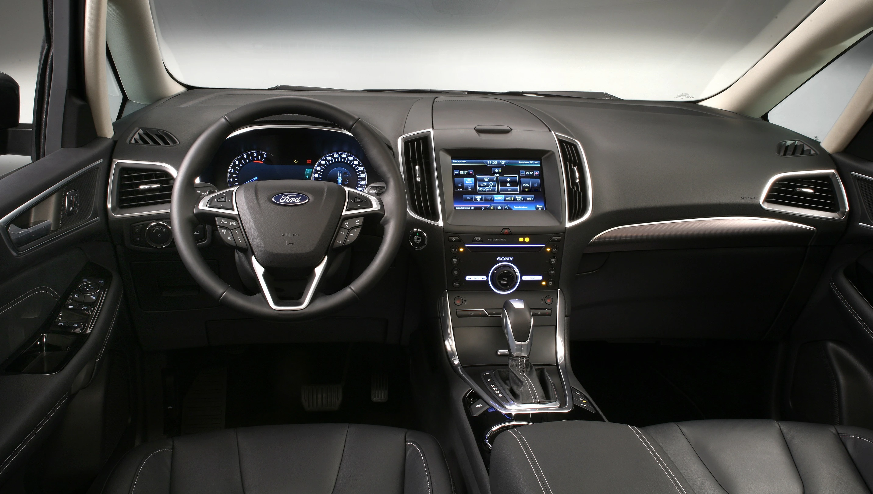 Innenraum eines modernen Autos mit Lederlenkrad, Touchscreen-Display und digitalen Anzeigen auf dem Armaturenbrett.