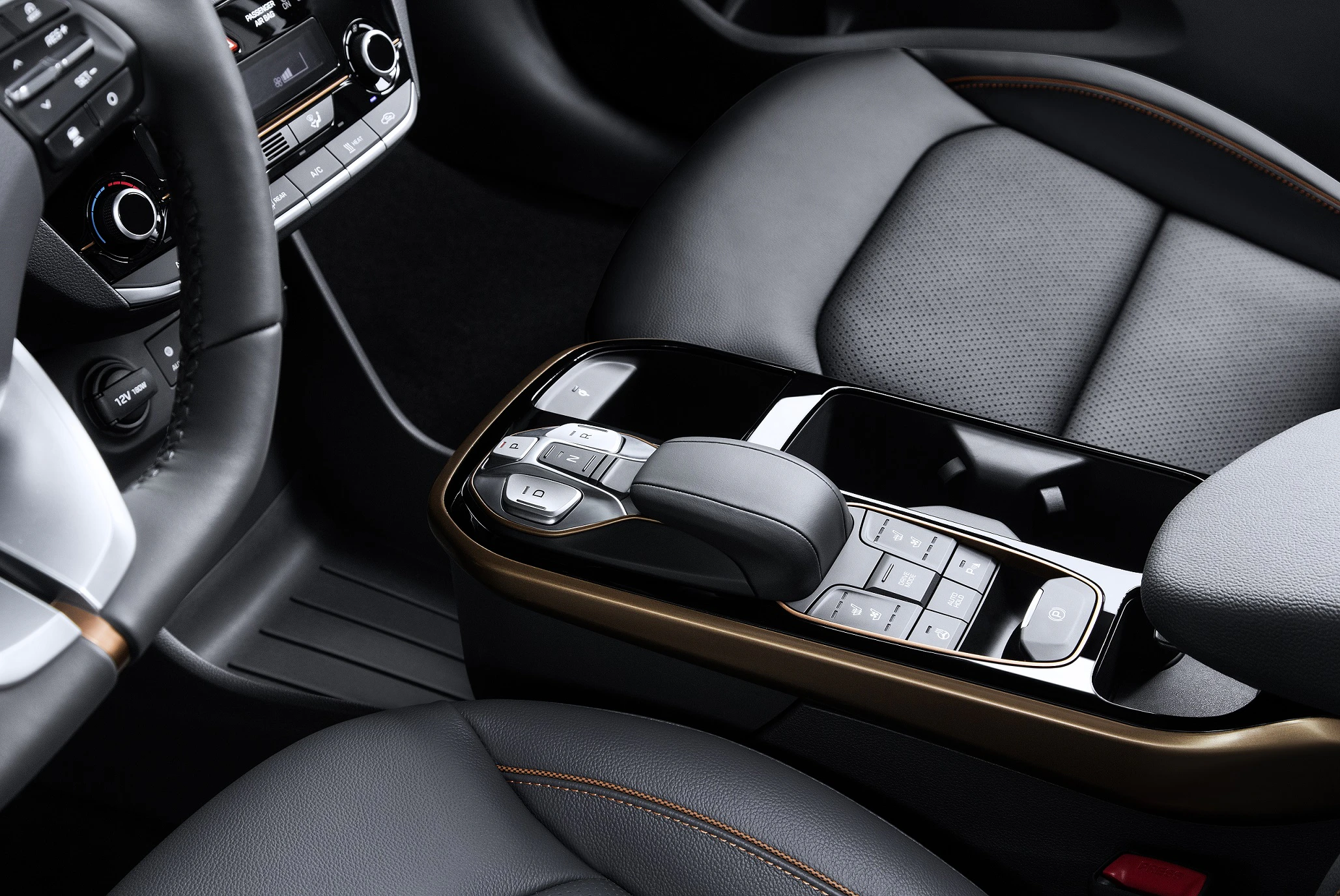 Nahaufnahme eines modernen Autoinnenraums mit Ledersitzen, einem geschwungenen Schalthebel und integriertem Touchscreen auf der Mittelkonsole.