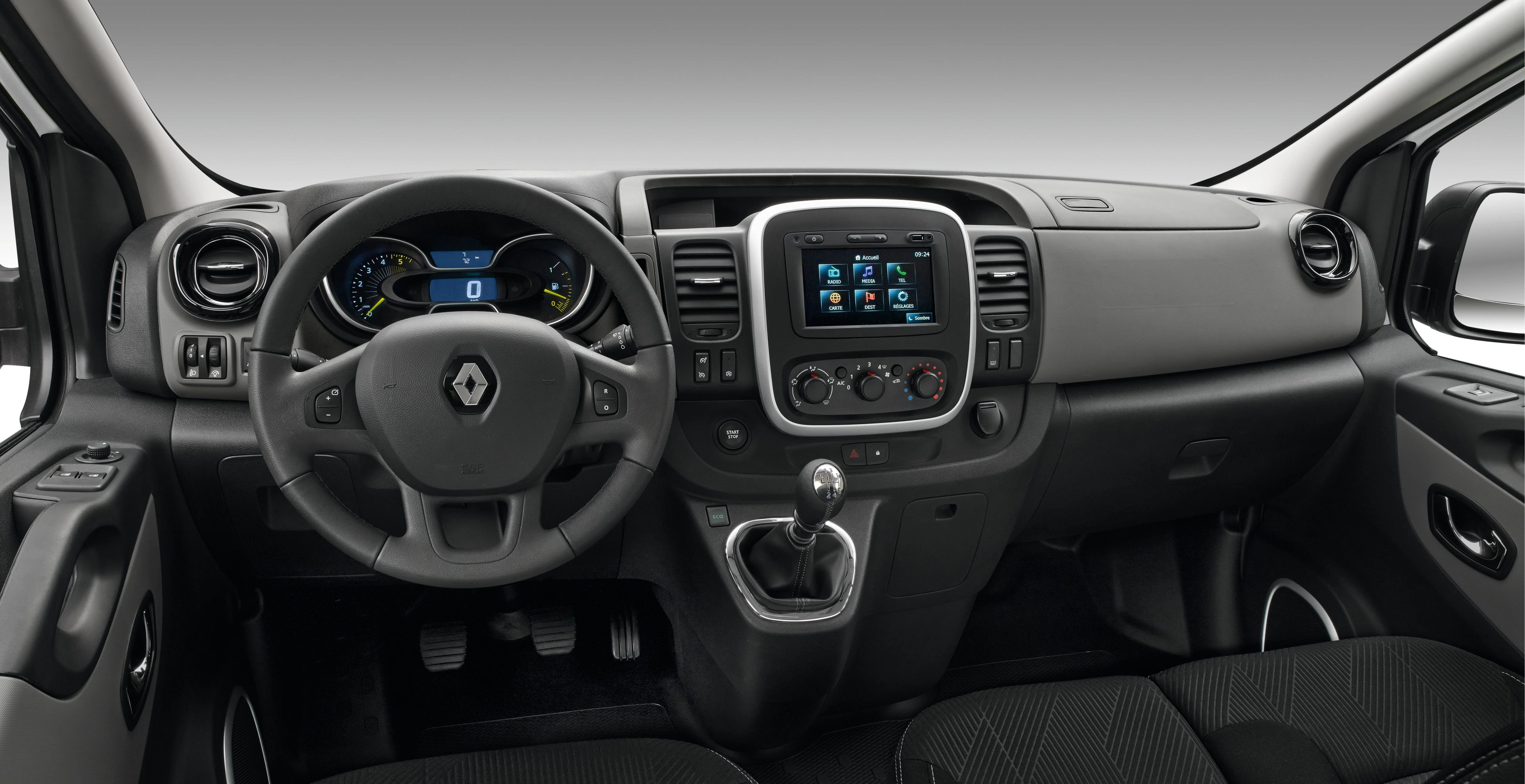 Innenraum eines Renault-Vans mit Lenkrad, Tachometer, Touchscreen-Display und manuellem Schaltgetriebe, in einem modernen, schwarzen Design.