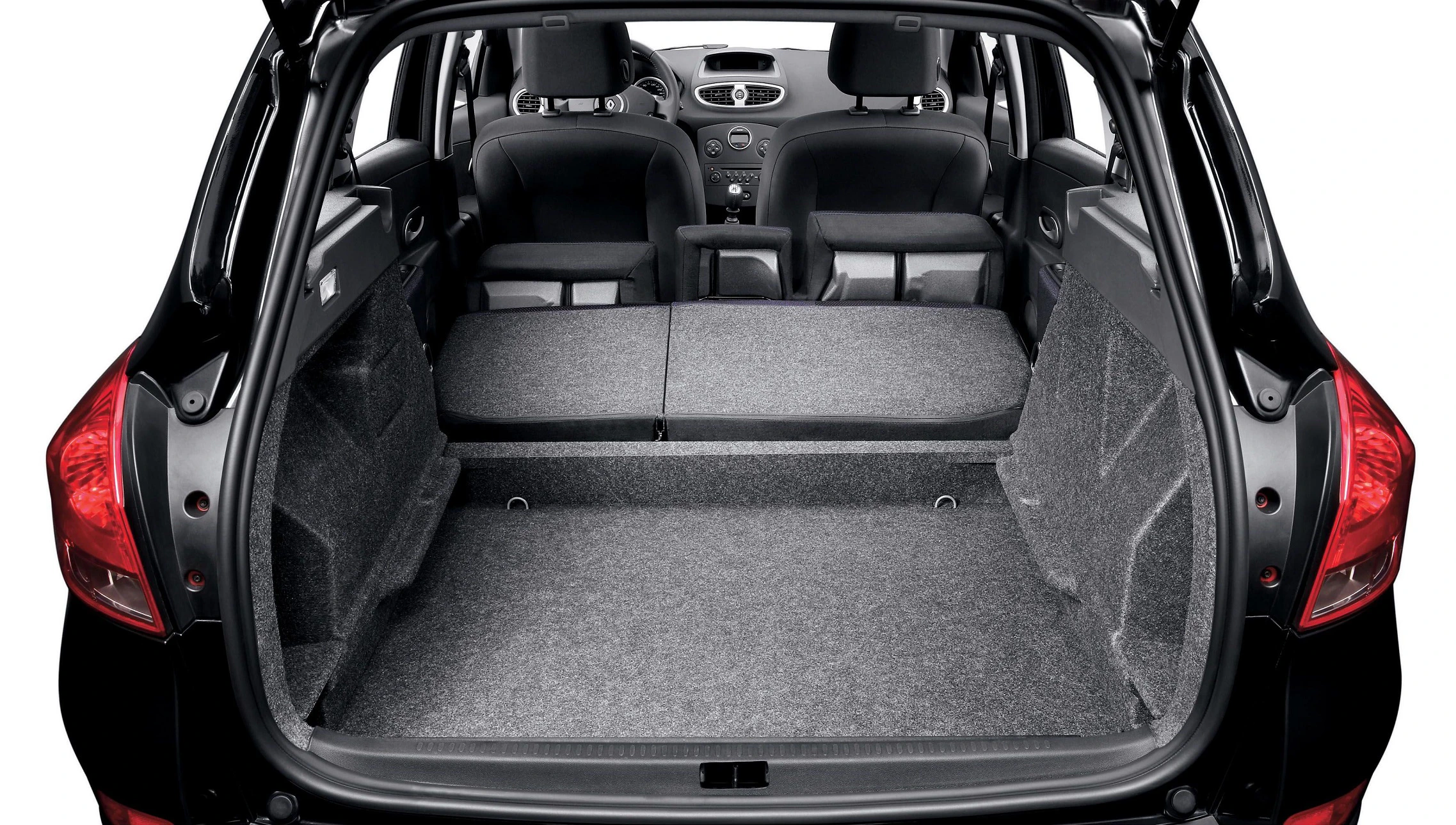 Der Innenraum eines Autos mit umgeklappter Rückbank, die viel Platz für Gepäck bietet. Die Sitze sind nach vorne gerichtet.