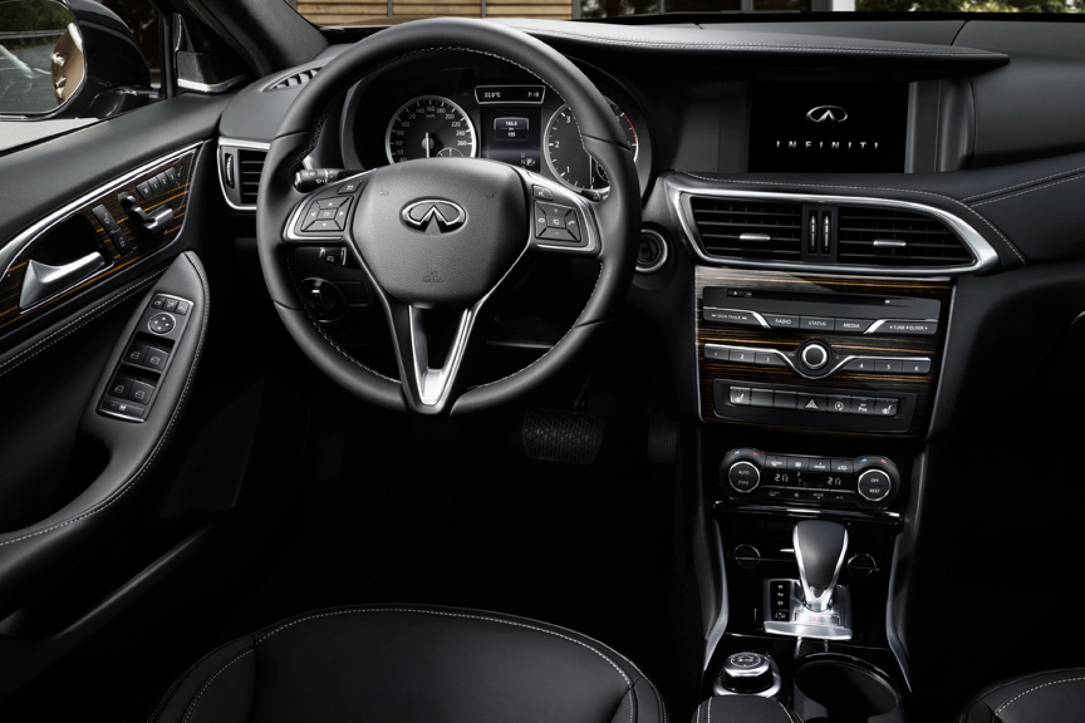 Innenraum eines modernen Autos mit Lederlenkrad, Instrumententafel und Infotainment-System auf dem Bildschirm in der Mittelkonsole.