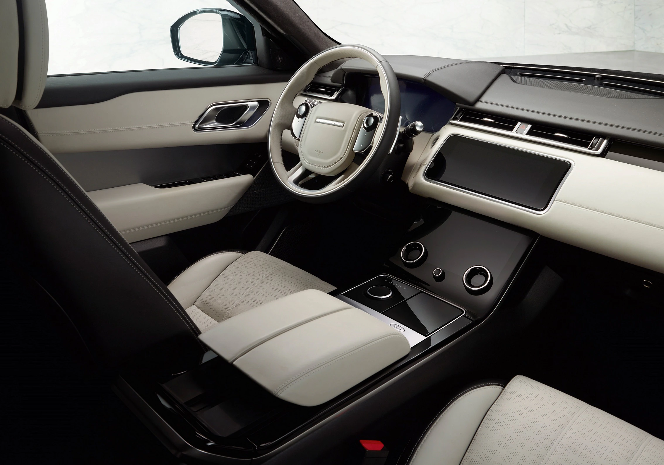 Moderner Autoinnenraum mit beige und schwarzen Ledersitzen, Lenkrad links, großem Touchscreen und minimalistischem Armaturenbrettdesign.