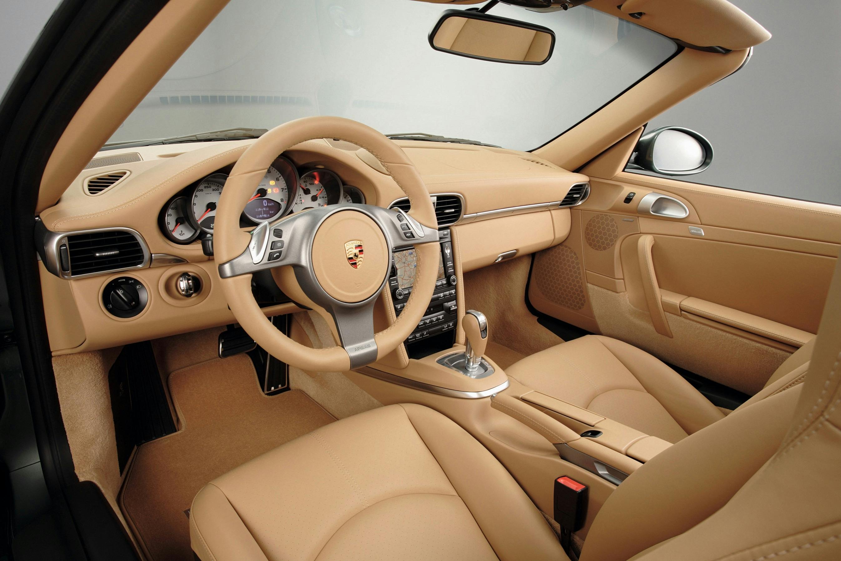 Innenraum eines Luxusautos mit beigem Leder, modernem Armaturenbrett und Multifunktionslenkrad. Hochwertige Verarbeitung sichtbar.