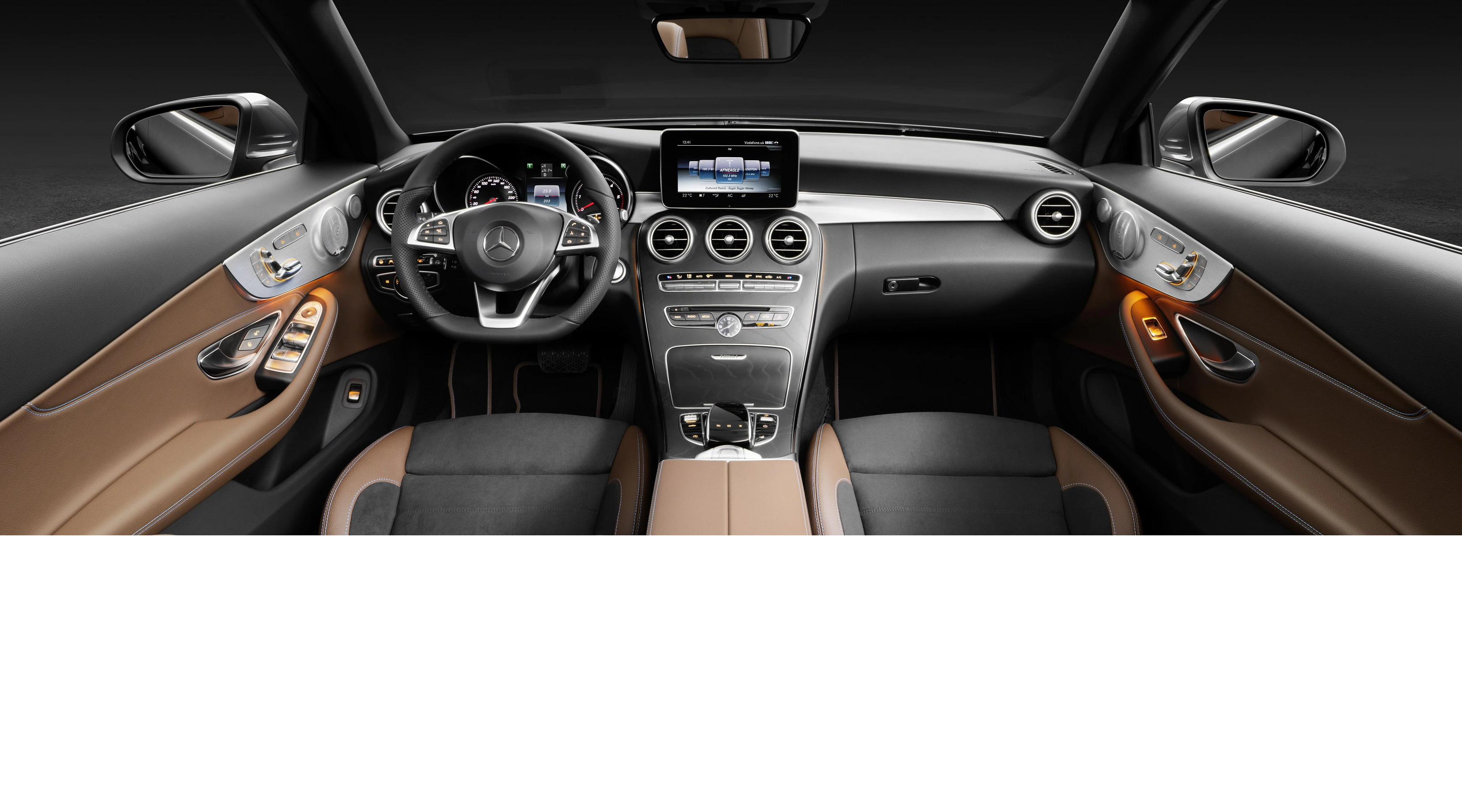 Innenraum eines Mercedes-Benz mit braun-schwarzem Leder, modernem Lenkrad, zentralem Display und eleganter Ausstattung.