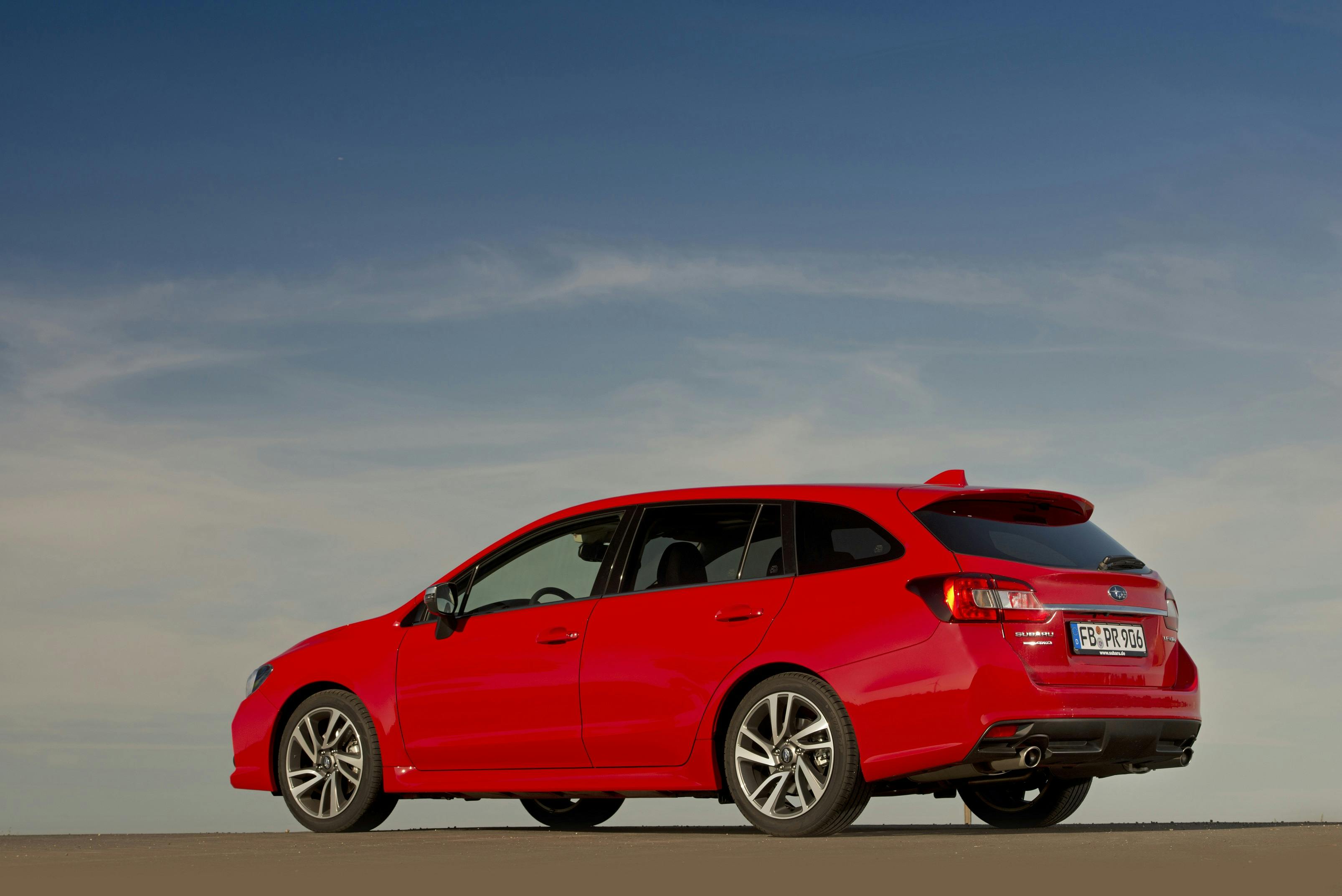 Roter Kombiwagen auf einem freien Platz unter klarem Himmel. Rückansicht zeigt sportliches Design.