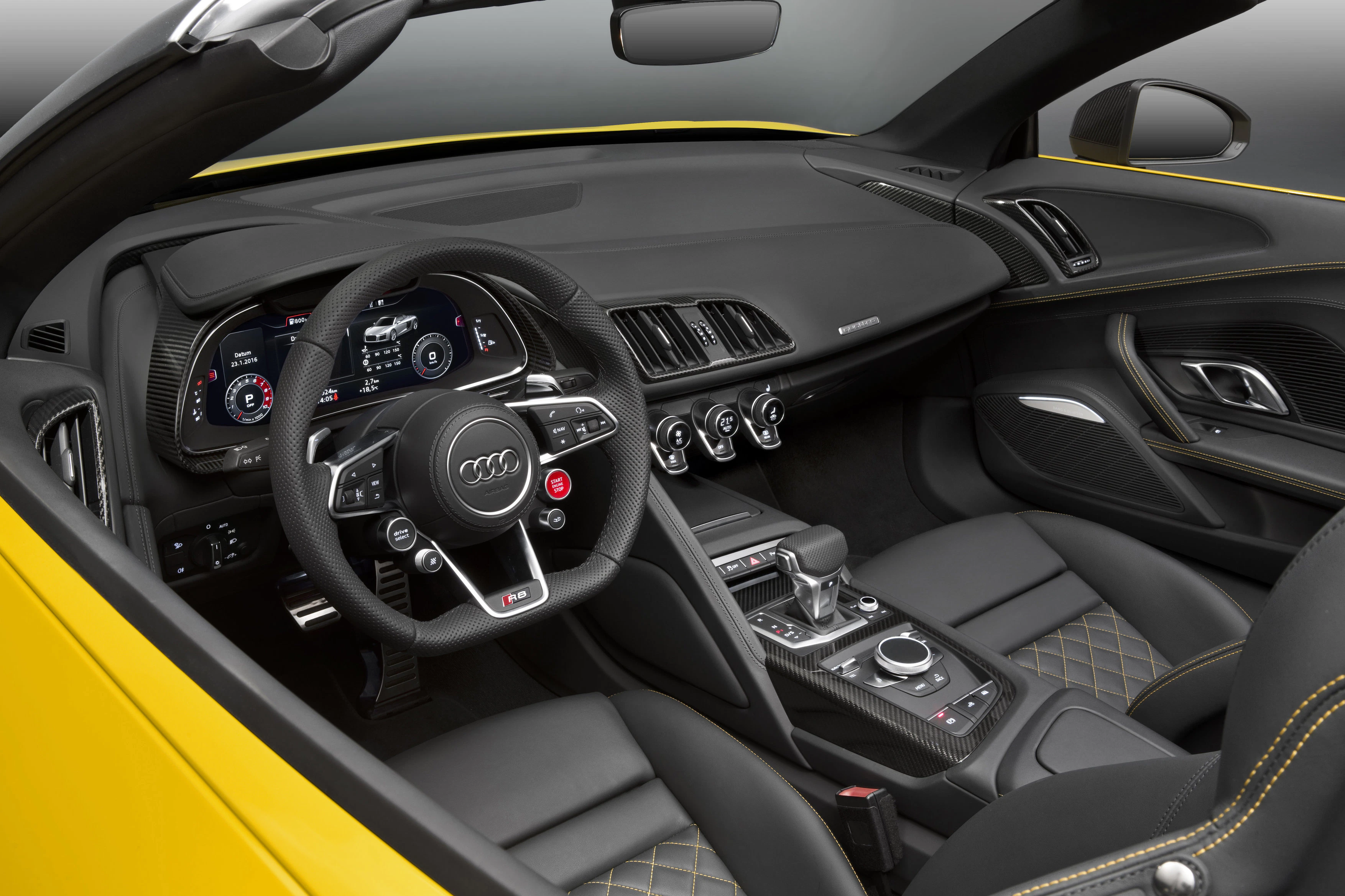 Gelbes Audi-Sportwagen-Interieur mit schwarzem Leder, Multifunktionslenkrad, digitalem Armaturenbrett und Kohlefaserakzenten.