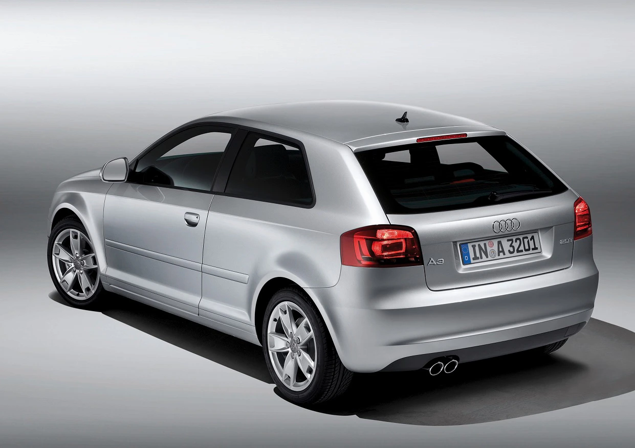 Silberner Audi A3 aus schräger Rückansicht auf grauem Hintergrund. Das Auto hat zwei Türen und ein deutsches Nummernschild.