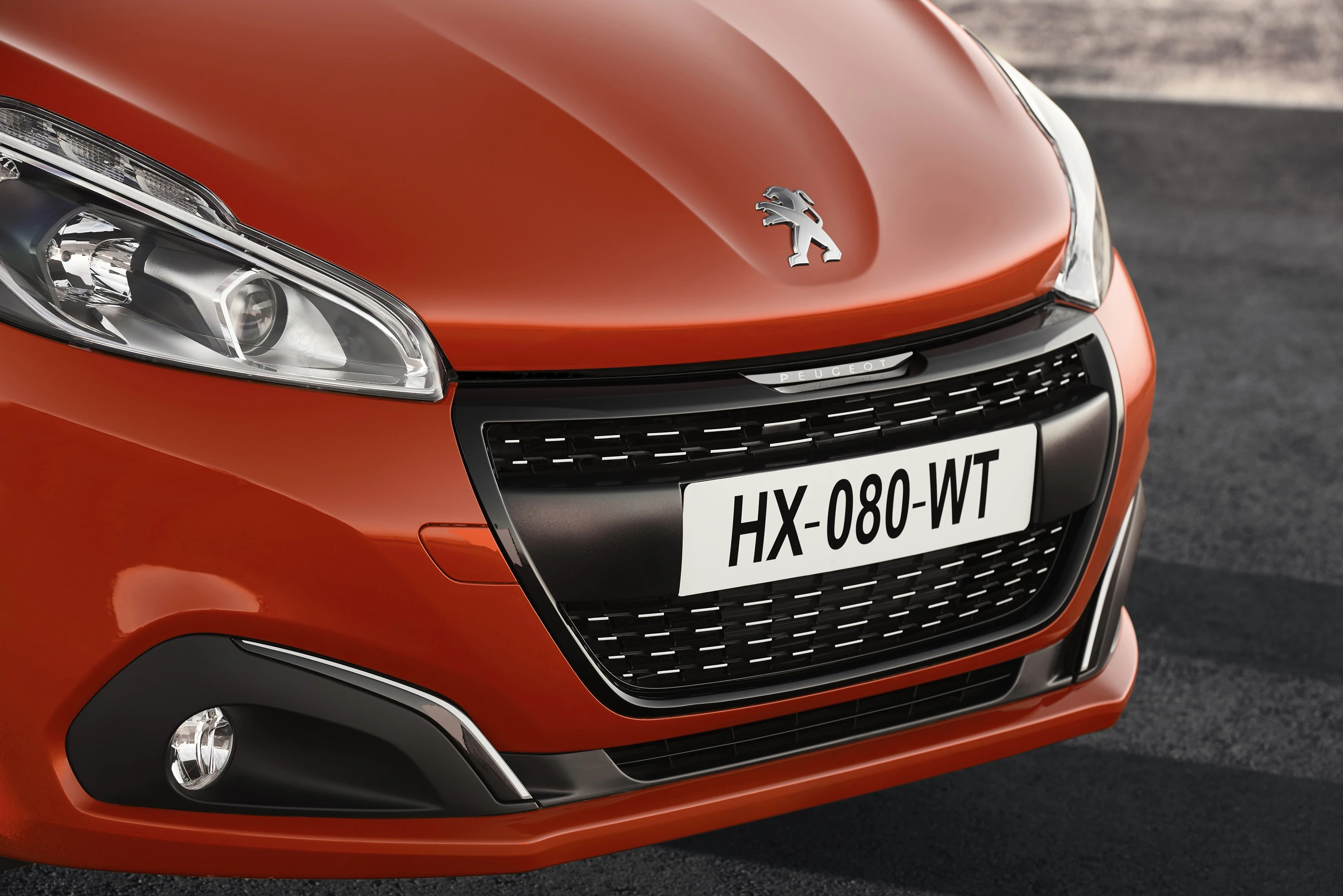 Roter Peugeot mit markantem Kühlergrill und Nummernschild "HX-080-WT" in Nahaufnahme, auf dunklem Asphalt geparkt.