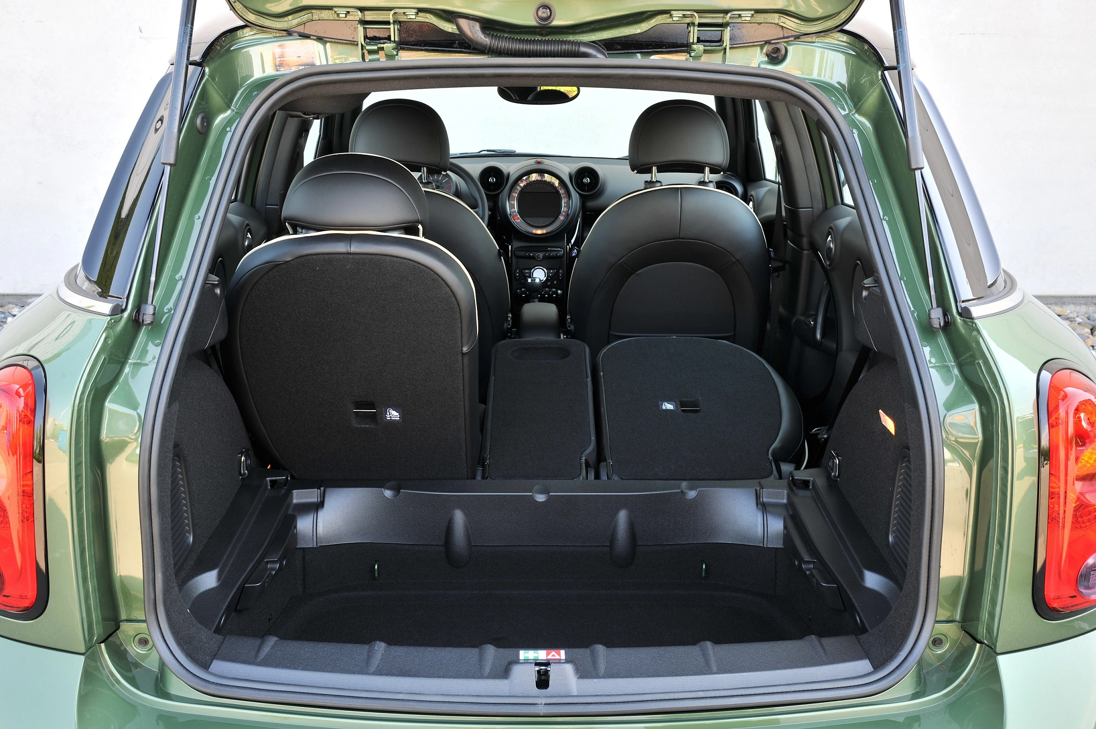 Kofferraum eines grünen Autos mit umgeklappten Rücksitzen, zeigt geräumigen Innenraum und Blick auf das Armaturenbrett.