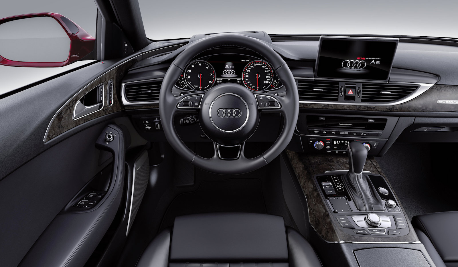 Innenraum eines Audi, modernes Cockpit mit Lederlenkrad, digitalen Anzeigen, Navigationsbildschirm und Mittelkonsole mit Schaltknüppel.