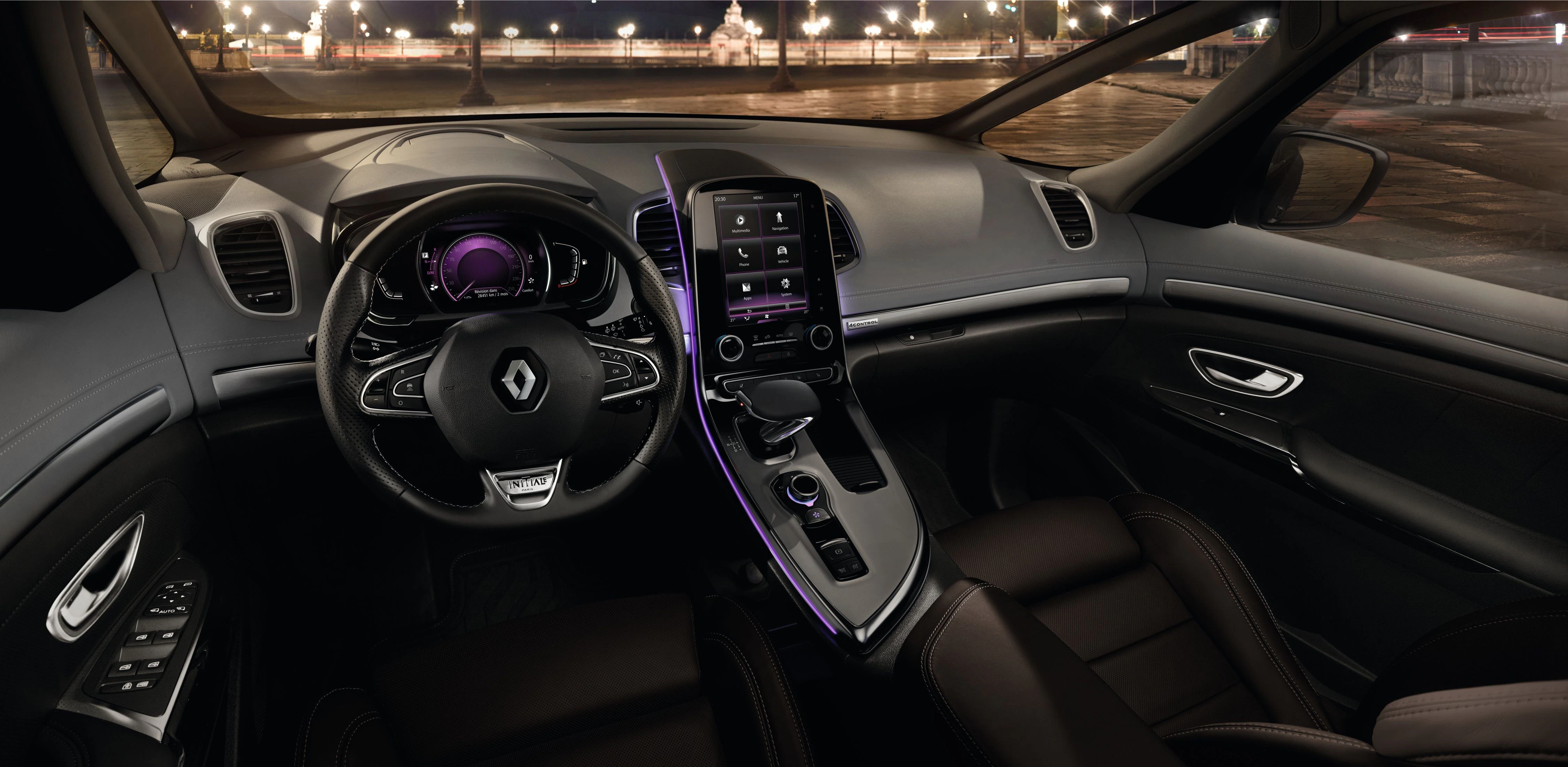 Innenraum eines modernen Renault-Autos mit beleuchtetem Armaturenbrett, großem Touchscreen, Lenkrad und Ledersitzen bei Nacht.