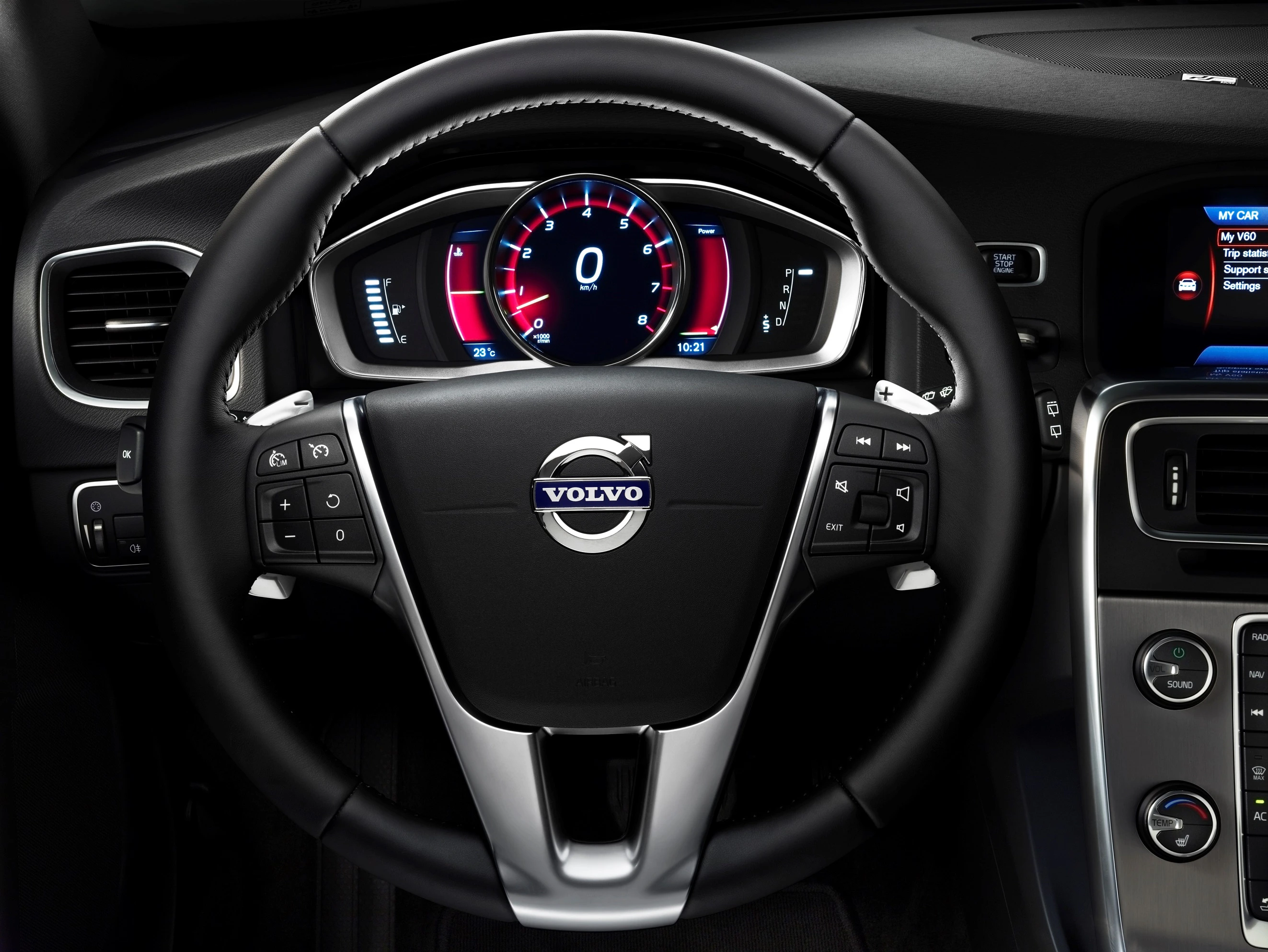 Nahaufnahme eines Volvo-Lenkrads mit digitalen Instrumentenanzeigen im Hintergrund, einschließlich Geschwindigkeits- und Tachometer.