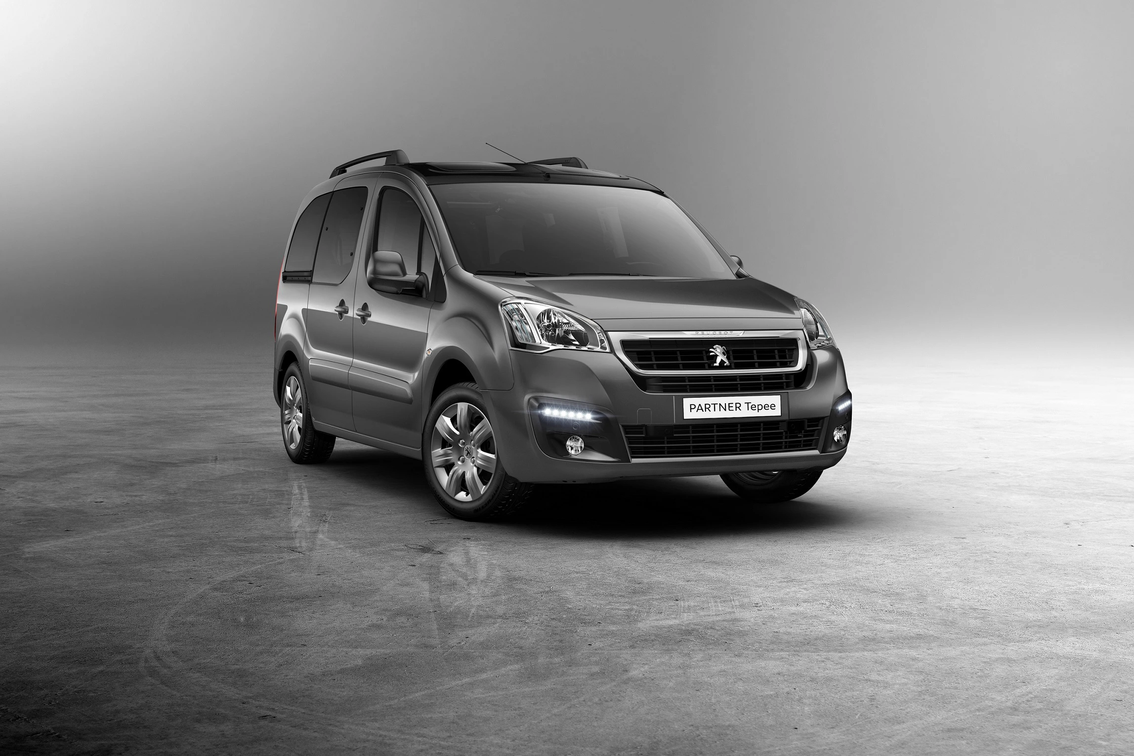 Silberner Peugeot Partner Tepee auf grauem Hintergrund, Vorderansicht, asymmetrisch nach links gerichtet.