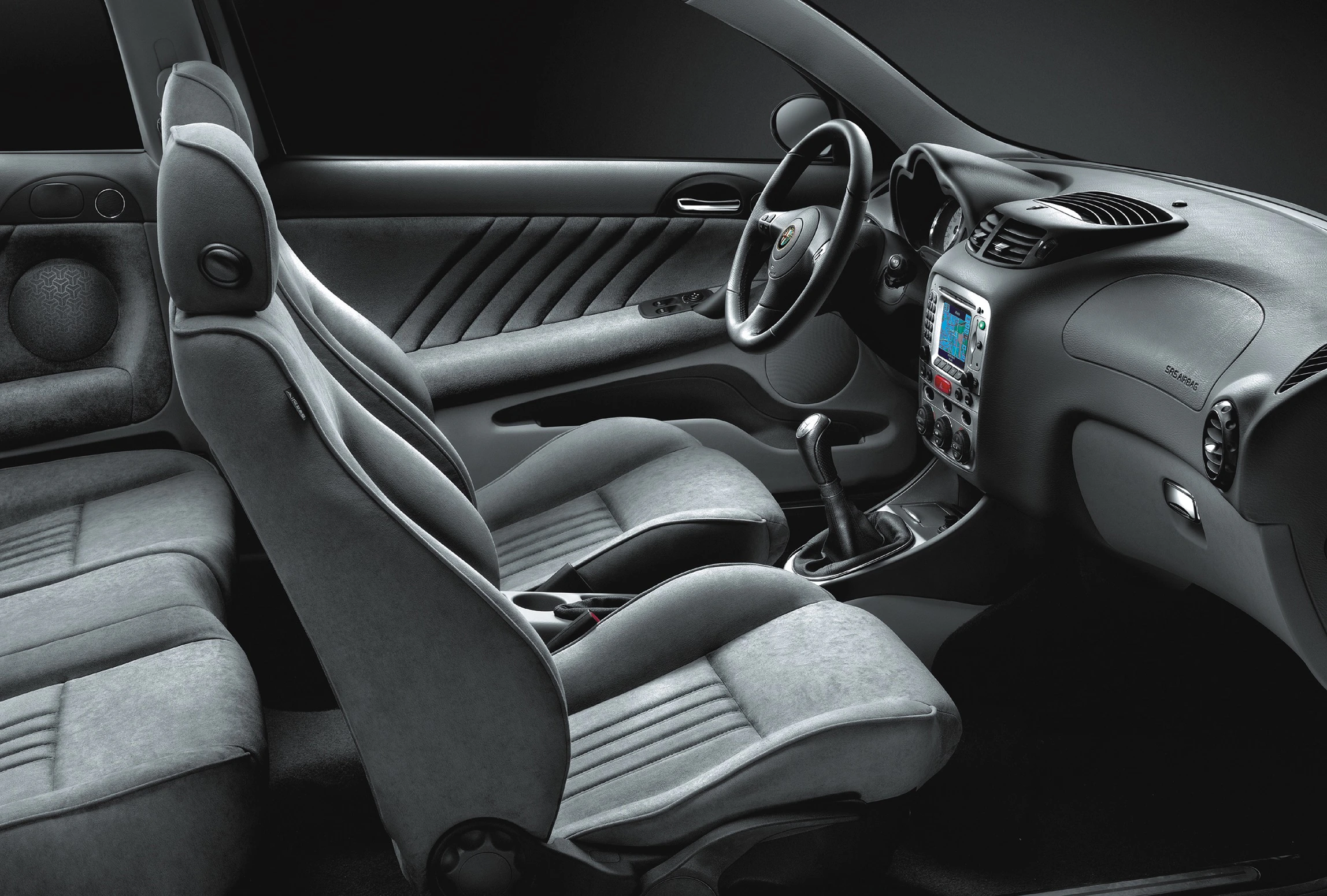 Innenansicht eines modernen Autos mit grauen Sitzen, Schalthebel, Lenkrad und Mittelkonsole. Elegantes, minimalistisches Design.