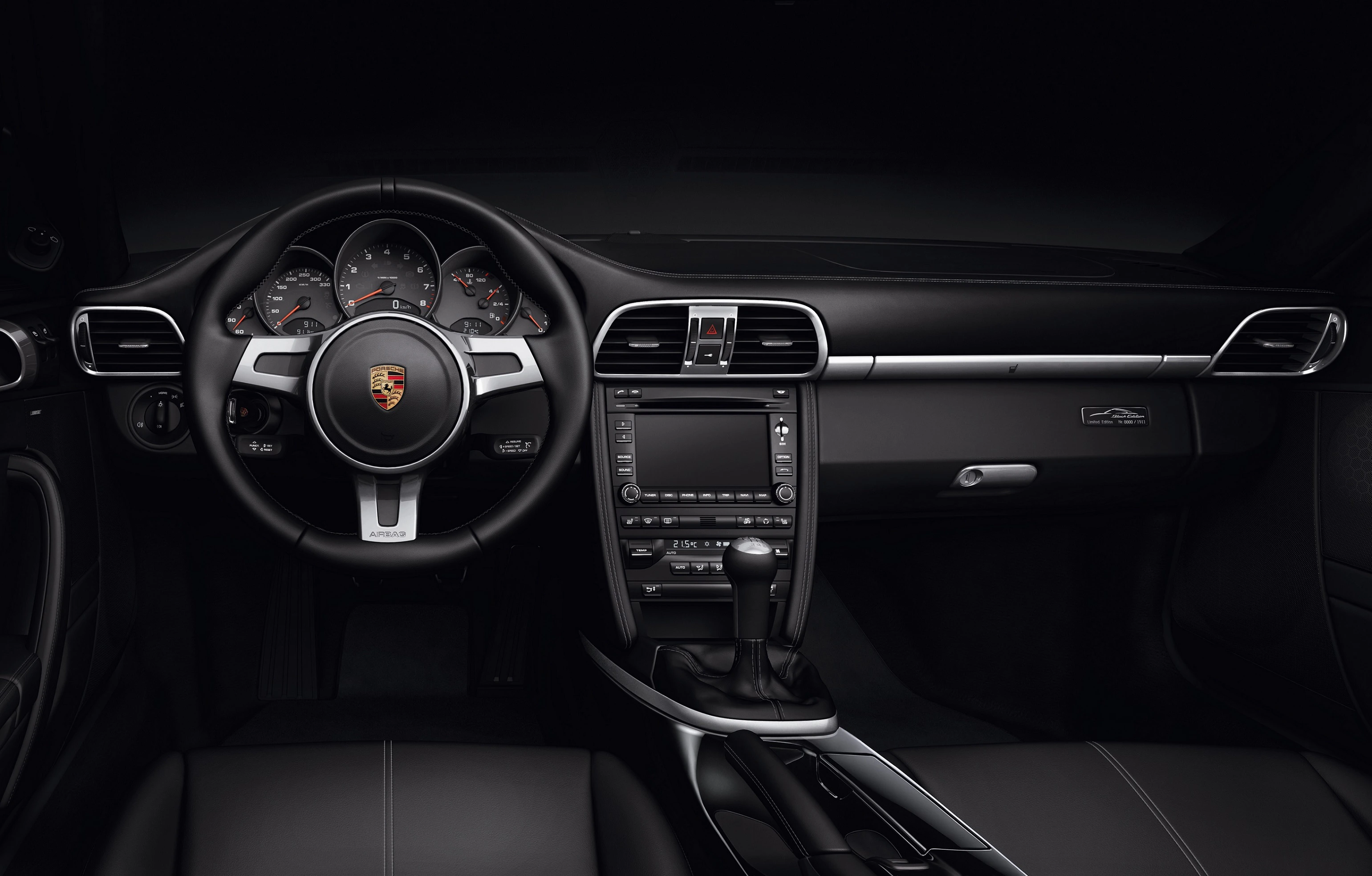 Innenraum eines modernen Autos mit schwarz-grauer Lederausstattung, zentralem Touchscreen und multifunktionalem Lenkrad.