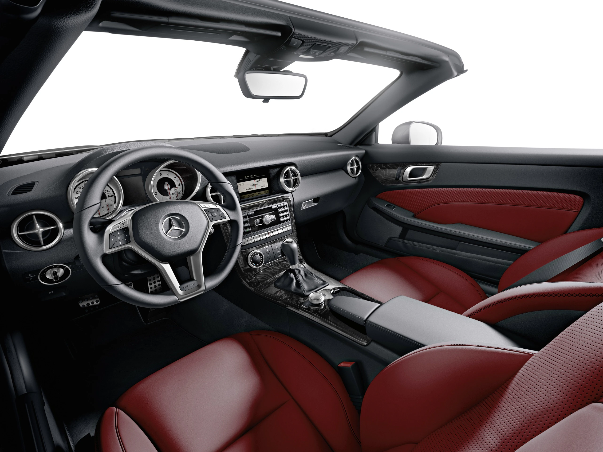 Innenraum eines Mercedes-Cabrios mit roten Ledersitzen, modernen Armaturen und eleganter Lenkradgestaltung.