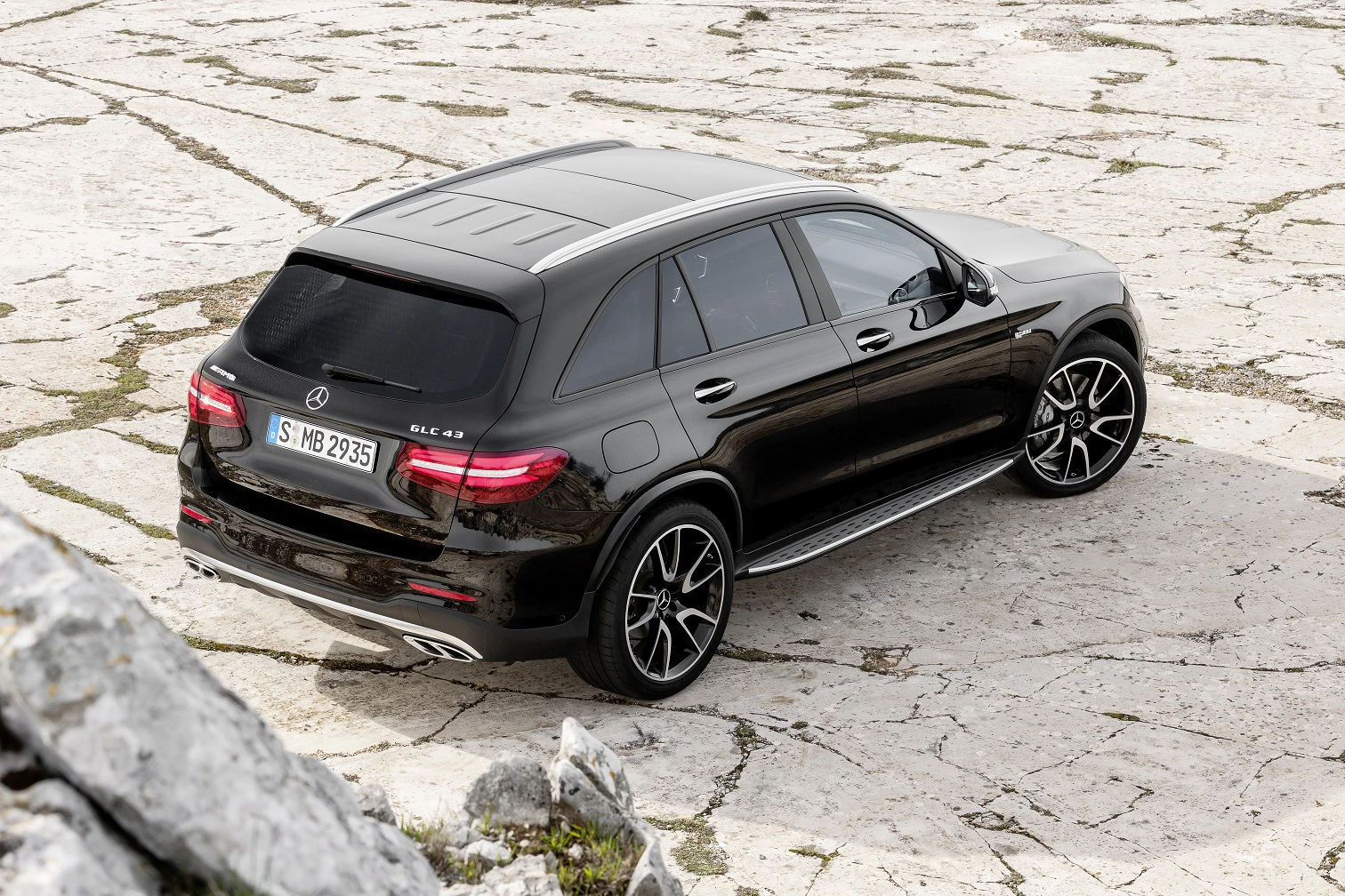 Schwarzer Mercedes SUV auf felsigem Untergrund, von hinten betrachtet. Elegantes Design mit sportlichen Felgen und getönten Fenstern.