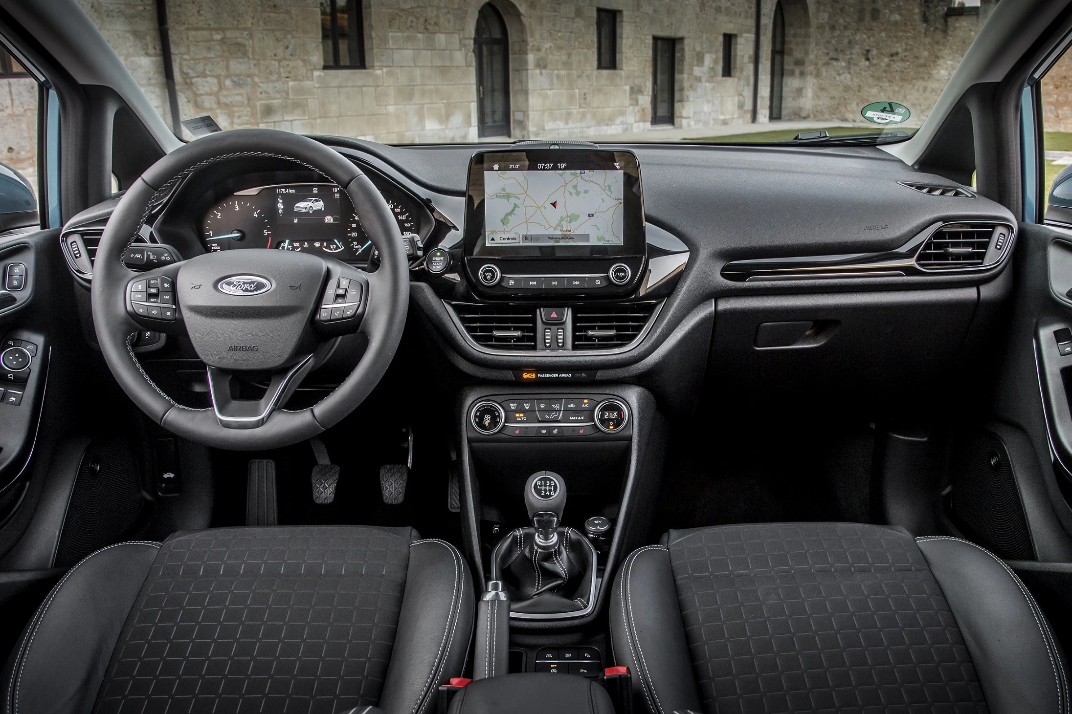 Innenraum eines Autos mit Lenkrad, digitalem Armaturenbrett und Touchscreen-Display mit Navigationskarte. Moderne Ausstattung und Design.