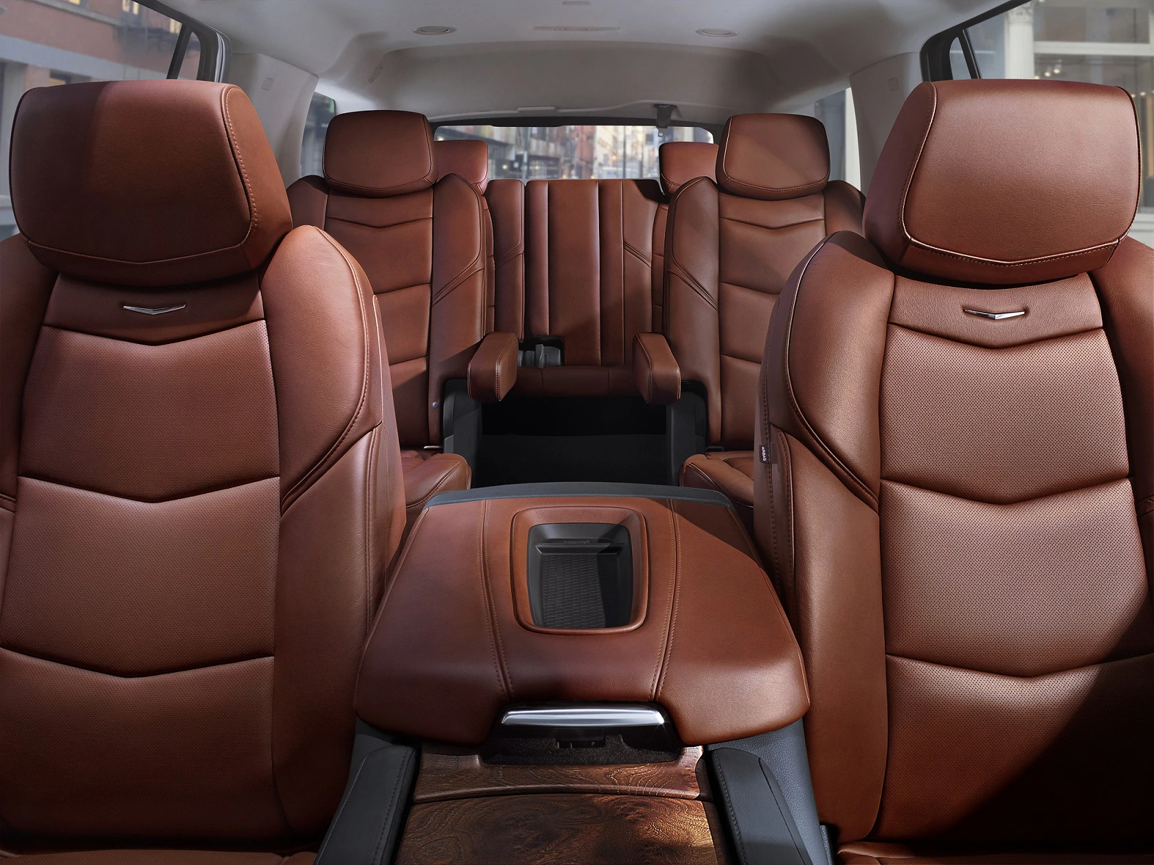 Luxuriöser Fahrzeuginnenraum mit sechs braunen Ledersitzen, geteilter Mittelkonsole und modernem Design.