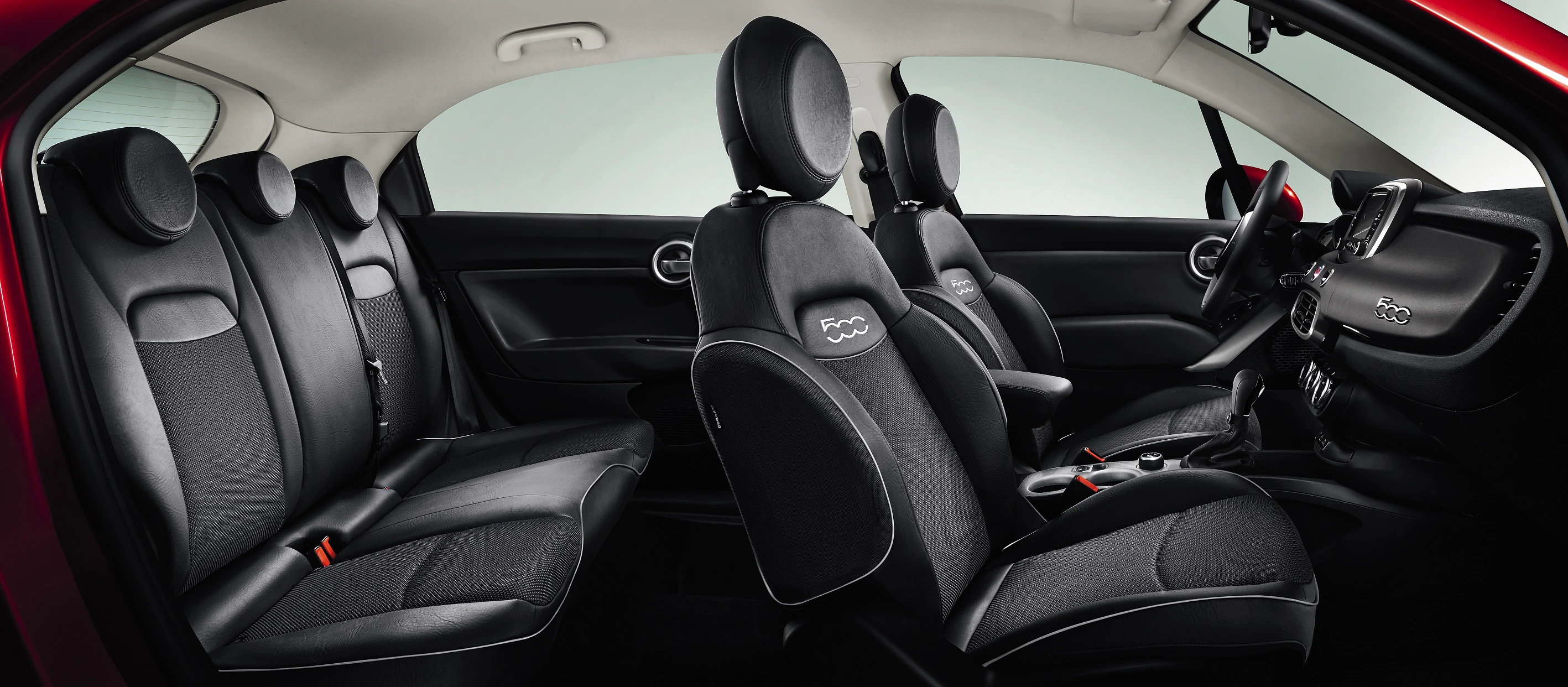 Innenraum eines Autos mit schwarzen Ledersitzen, stilvollem Armaturenbrett und modernen Designelementen, überwiegend in Schwarz gehalten.