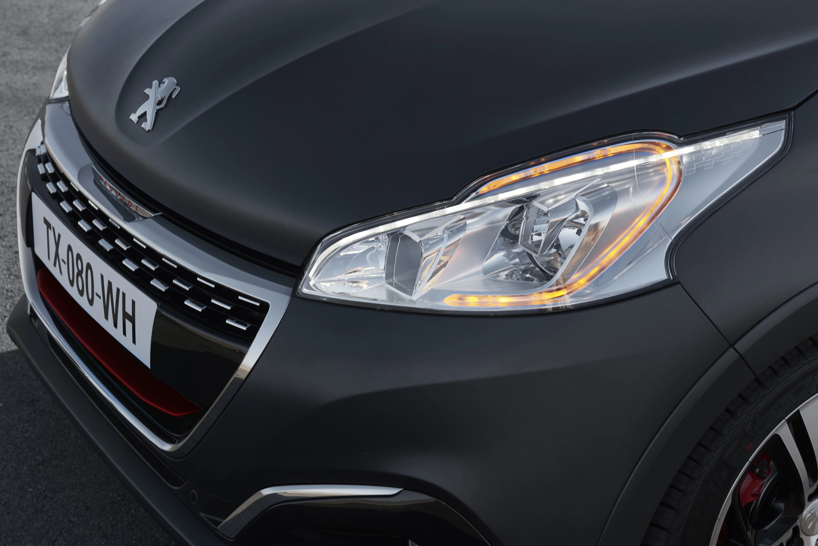 Nahaufnahme eines schwarzen Peugeot mit LED-Scheinwerfer und französischem Kennzeichen.