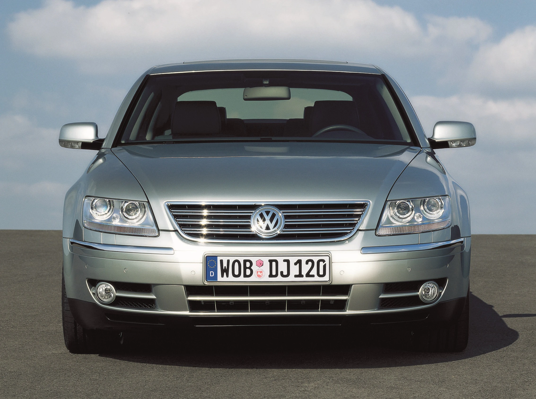 Silberner Volkswagen Phaeton, Frontansicht, auf einer Straße bei blauem Himmel. Nummernschild mit "WOB DJ120".