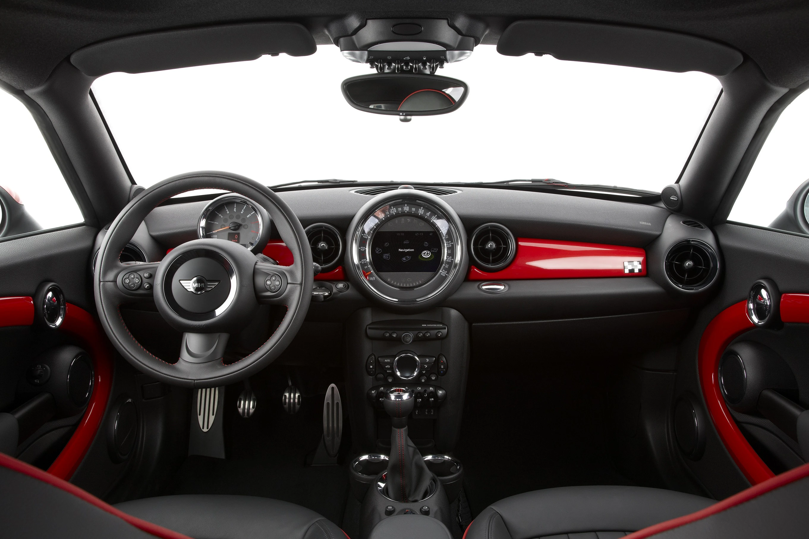 Innenraum eines modernen Autos mit schwarzem und rotem Armaturenbrett. Runde Kontrollanzeigen, Multifunktionslenkrad, Display und Mittelkonsole.