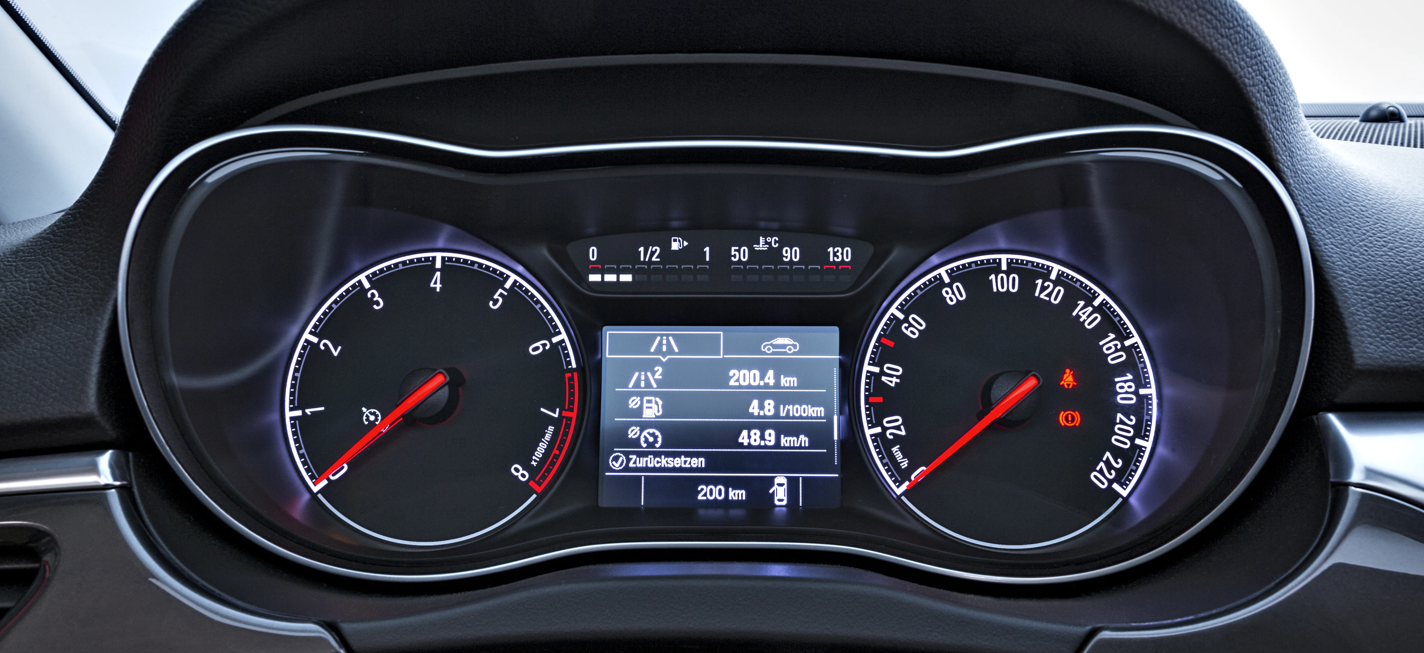 Nahaufnahme eines Auto-Tachometers mit Geschwindigkeitsanzeige, Drehzahlmesser und digitalen Anzeigen für Kilometerstand und Fahrinformationen.