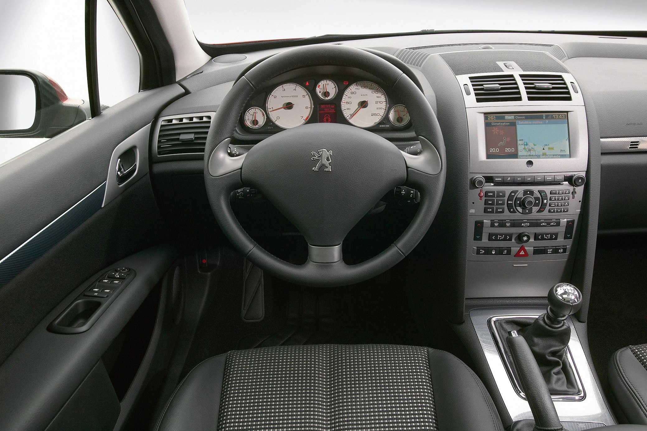 Innenraum eines Autos mit Lenkrad, Armaturenbrett, Navigationssystem und Schalthebel. Ein modernes, gut ausgestattetes Cockpit.