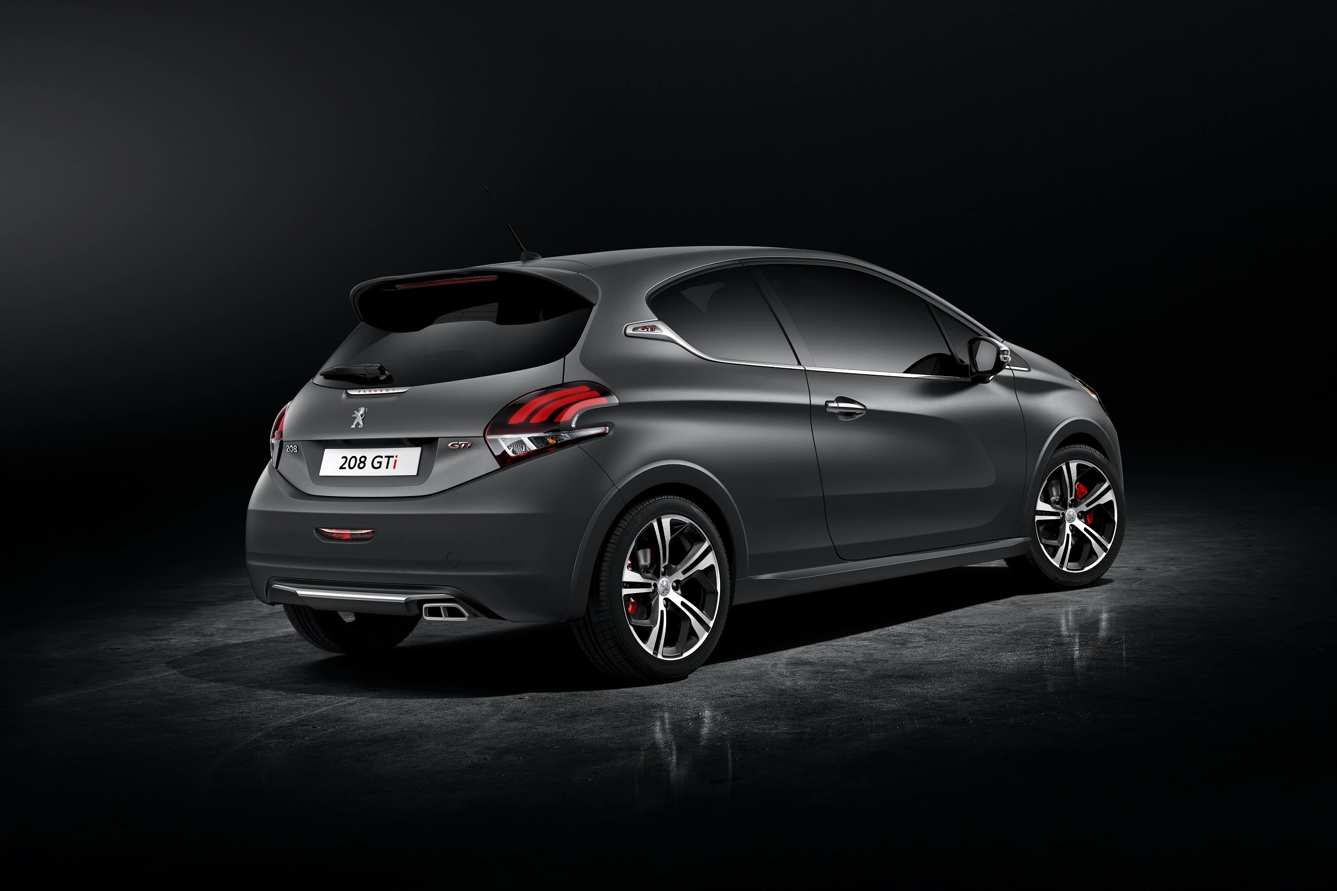 Schwarzer Peugeot 208 GTI von hinten in einem dunklen Studio, klarer Blick auf sportliches Design und Doppelauspuff.