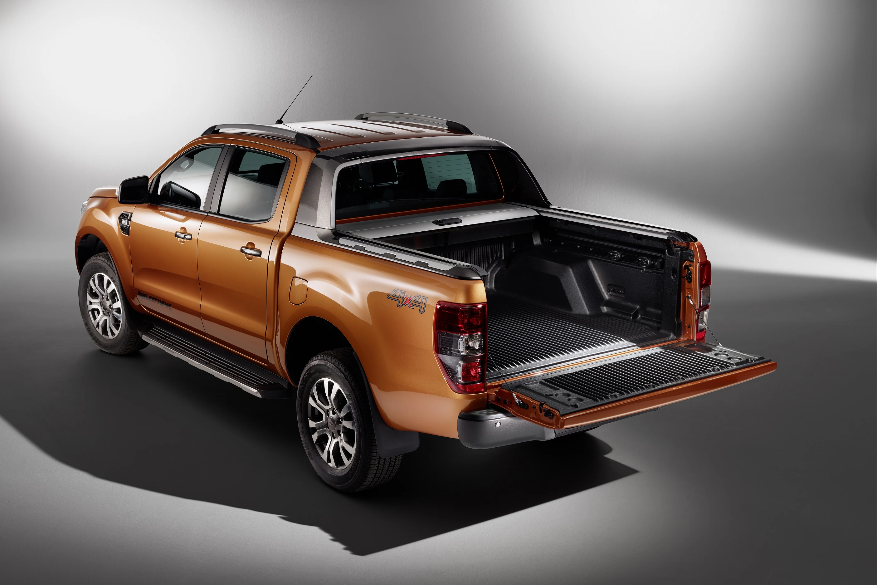 Brauner Pick-up-Truck mit geöffneter Ladefläche, stilvoll in einem Studio beleuchtet. Hervorgehobene Lackierung und moderne Designelemente.
