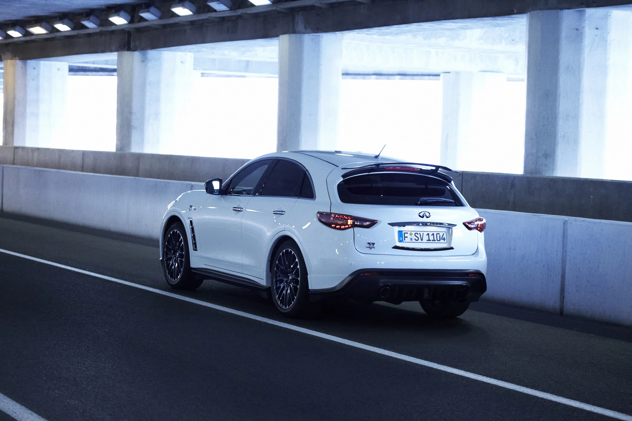 Weißer SUV fährt durch einen beleuchteten Straßentunnel. Er ist auf der rechten Fahrspur unterwegs und zeigt ein modernes Design.