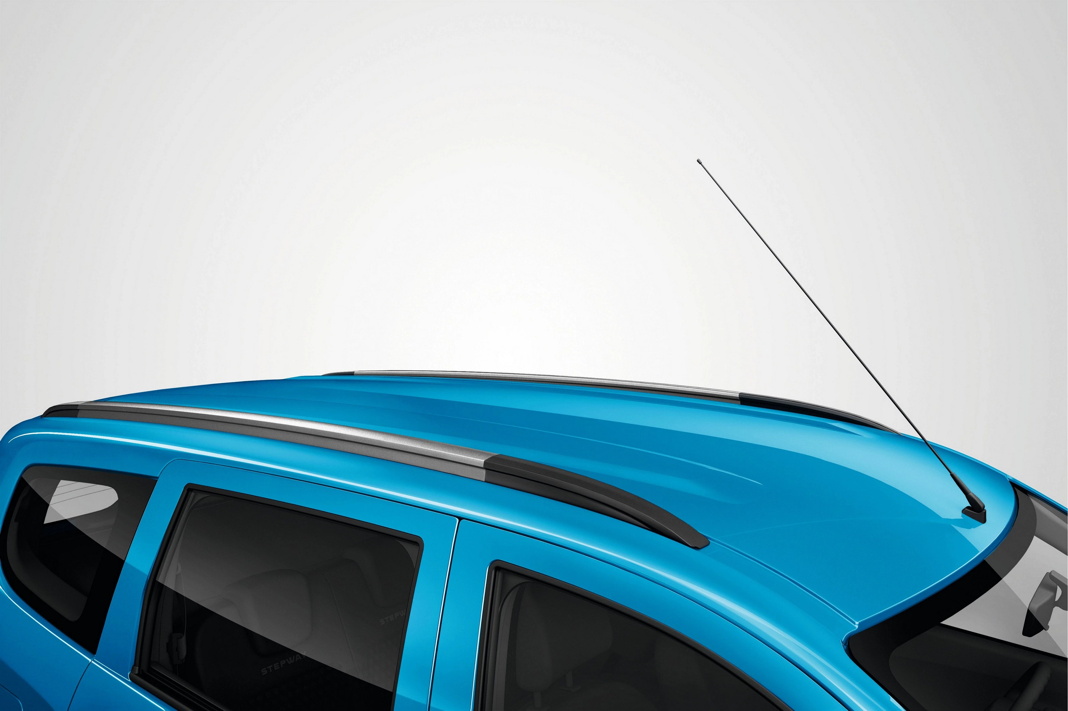 Blaues Autodach mit Dachreling und Antenne vor hellem Hintergrund.