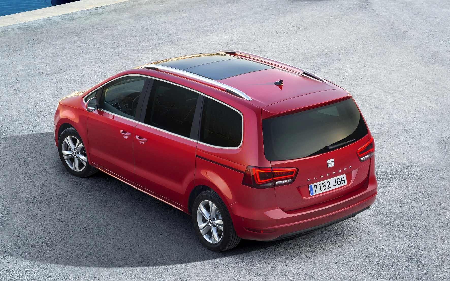 Roter SEAT Alhambra Minivan von oben fotografiert, auf einer asphaltierten Fläche. Schiebetüren und Panorama-Glasdach erkennbar.