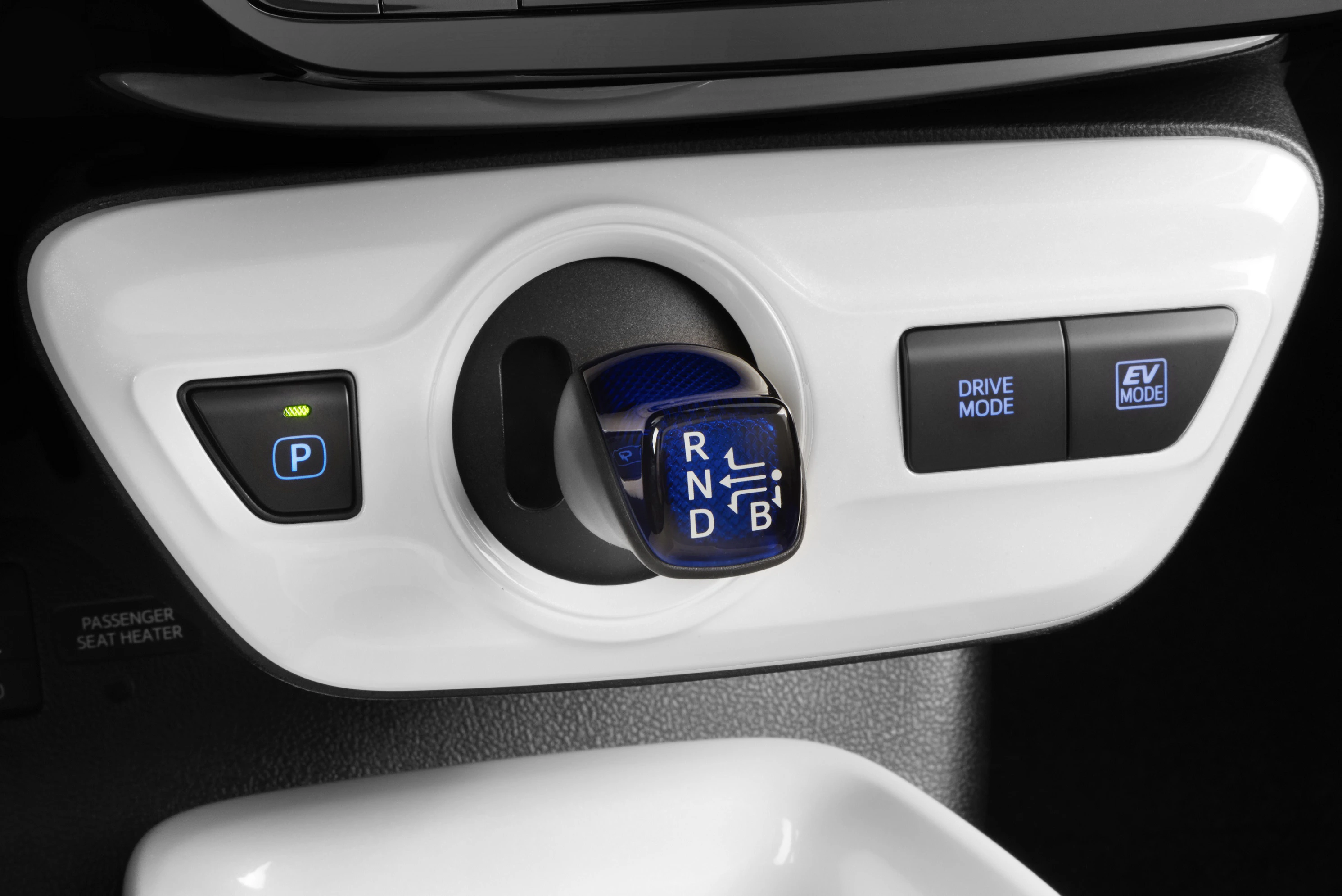 Nahaufnahme eines elektronischen Schalthebels in einem Auto, umgeben von Tasten für Parkmodus, Fahrmodus und Elektrofahrmodus.