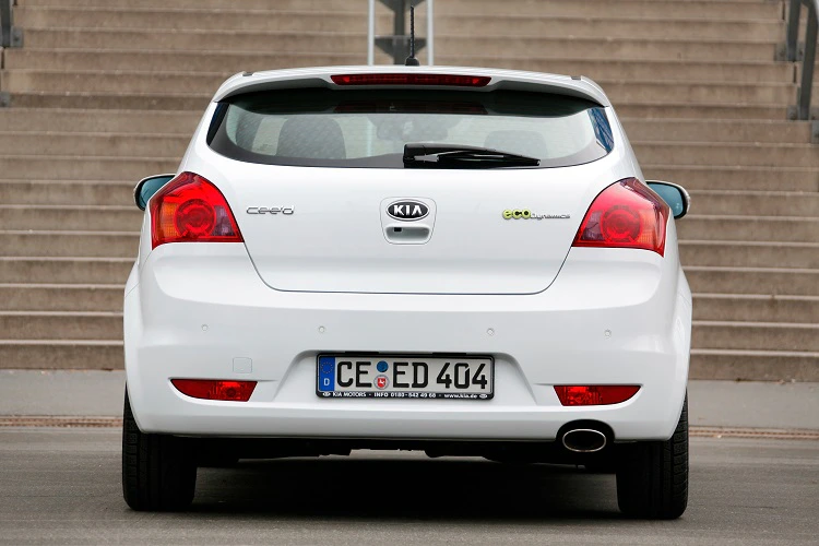 Rückansicht eines weißen Kia cee'd vor einer Treppe mit deutschem Kennzeichen CE-ED 404.