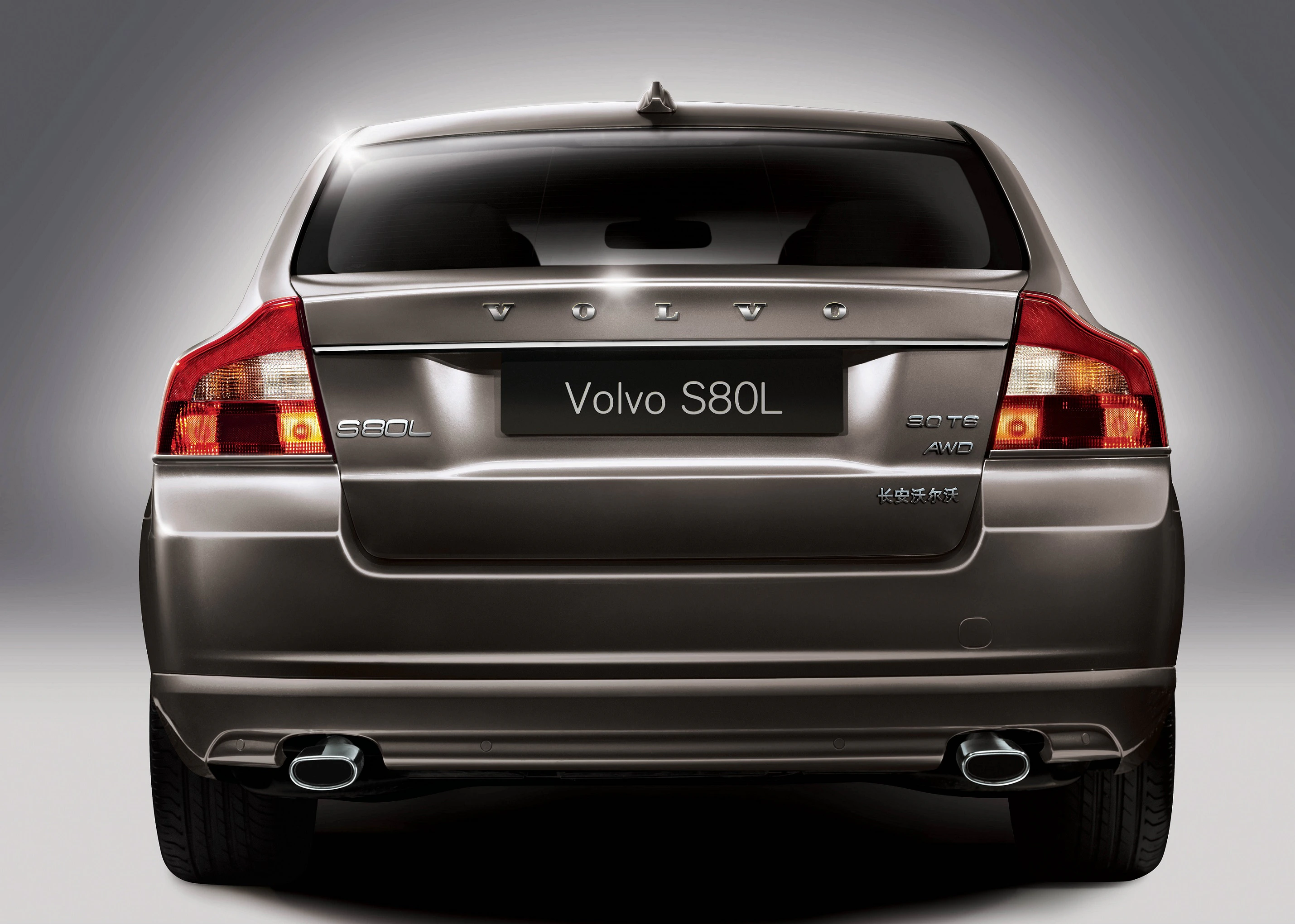 Rückansicht eines grauen Volvo S80L Autos, sichtbar sind Heckleuchten, Auspuffrohre und Embleme auf dem Kofferraum.
