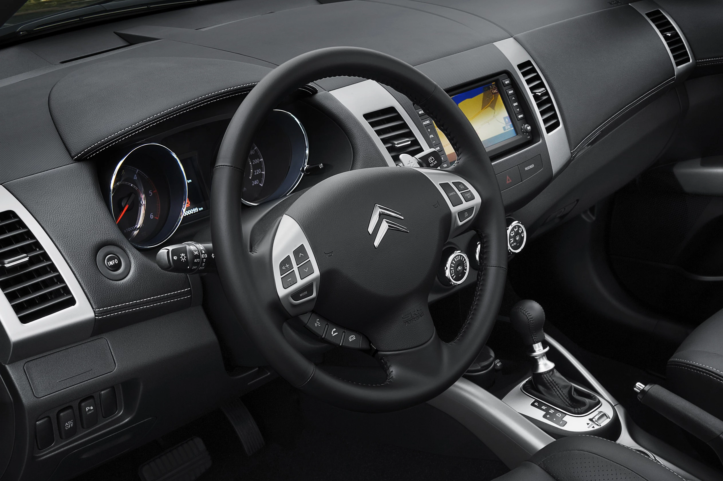 Innenraum eines Autos mit Citroën-Logo auf dem Lenkrad, einem Touchscreen in der Mittelkonsole und einem Automatikgetriebe.